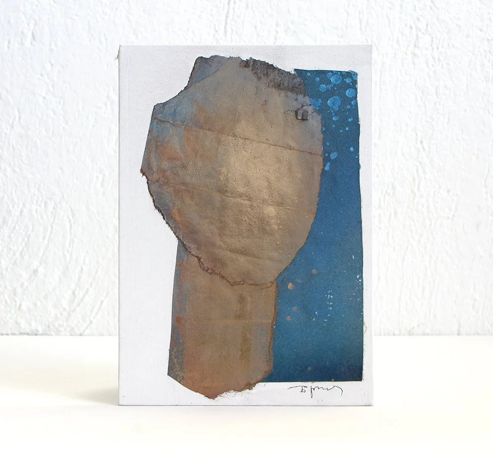An abstract painting of a torn piece of cardboard with a blue background and paint splatters with abstract head