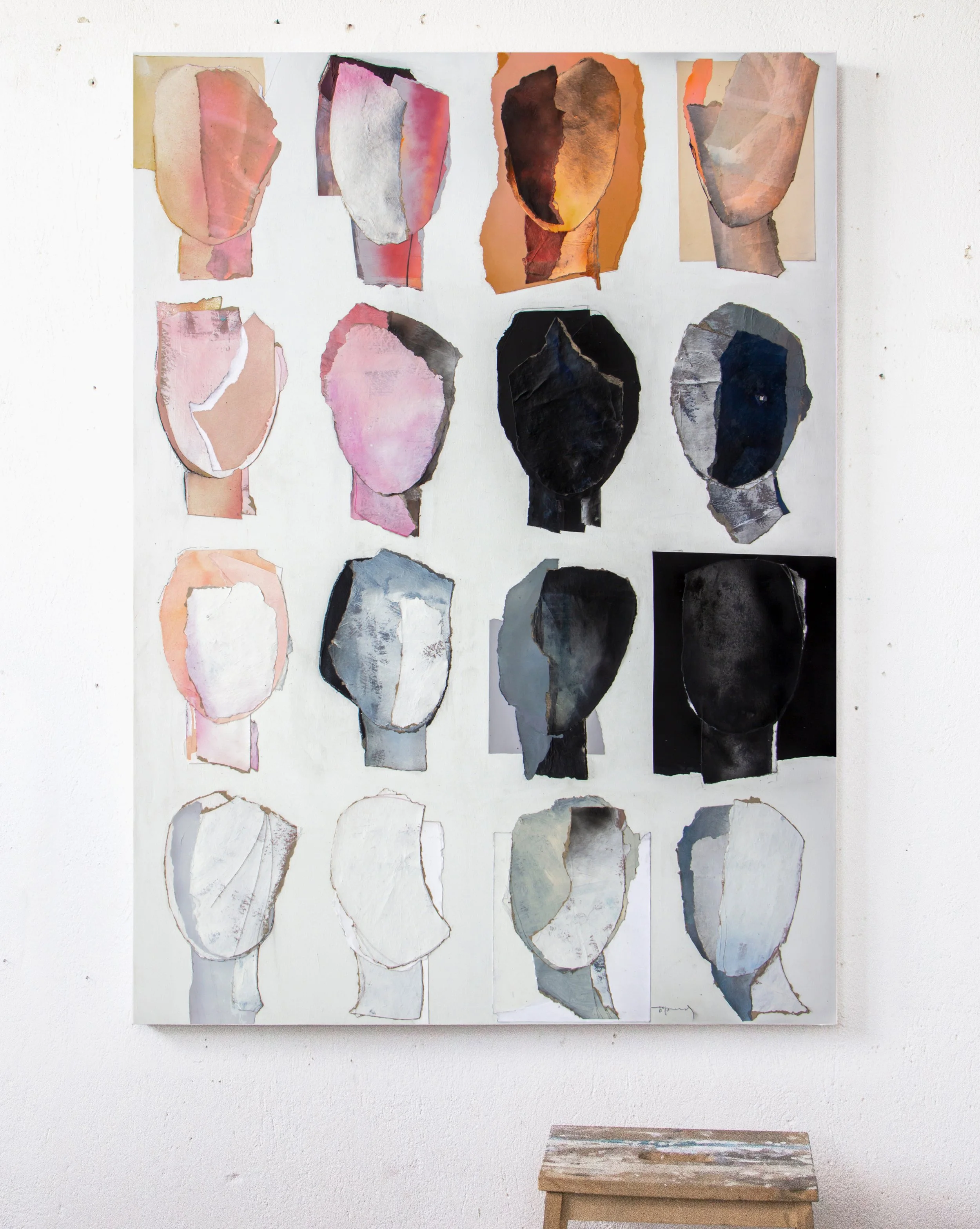 A large abstract art piece featuring multiple painted paper collages of faceless human profiles arranged in a grid on a white wall.