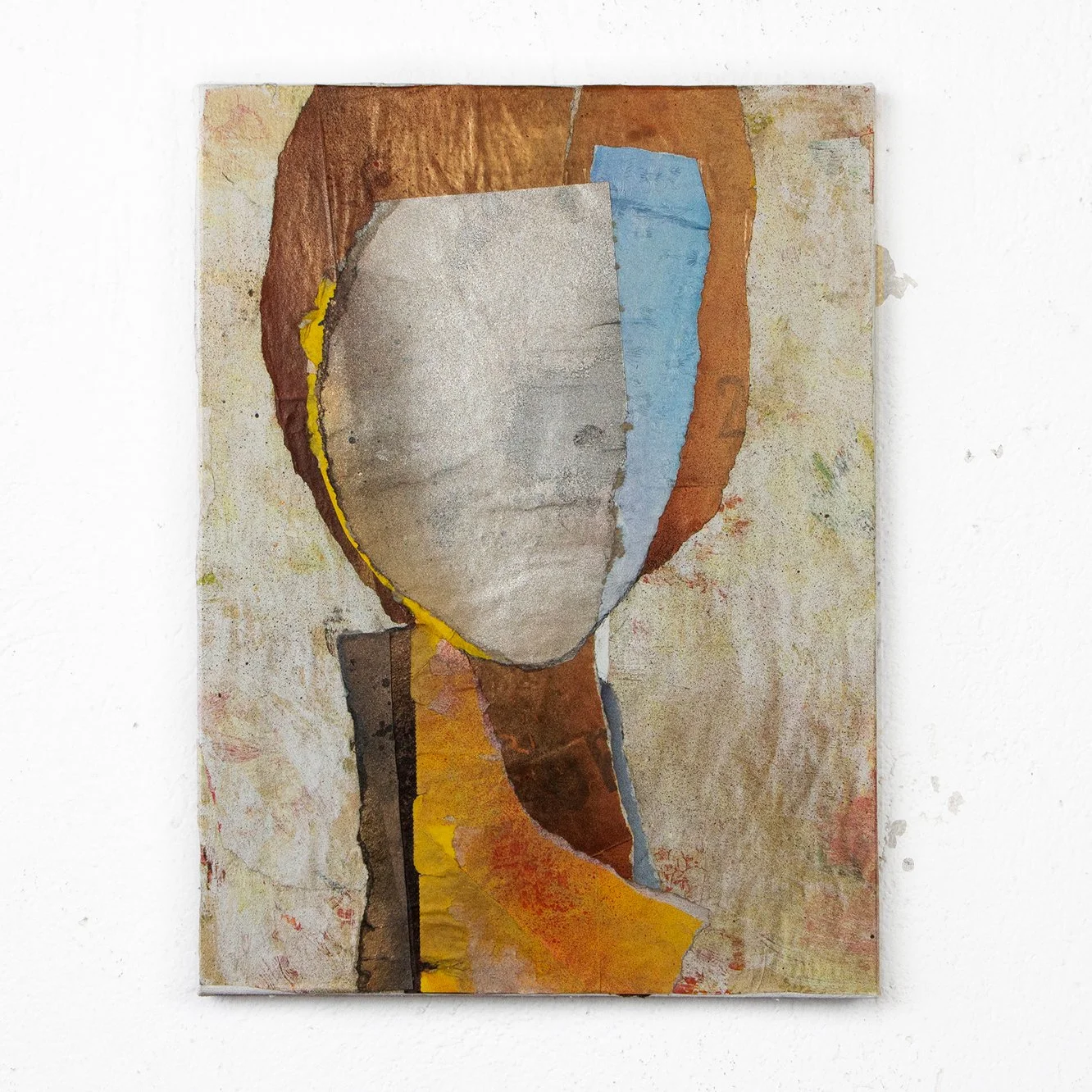 Abstract mixed media painting on canvas featuring a human face with a collage style, using various torn paper textures and colors including gray, brown, blue, yellow, and beige, with a focus on surface and layered elements.