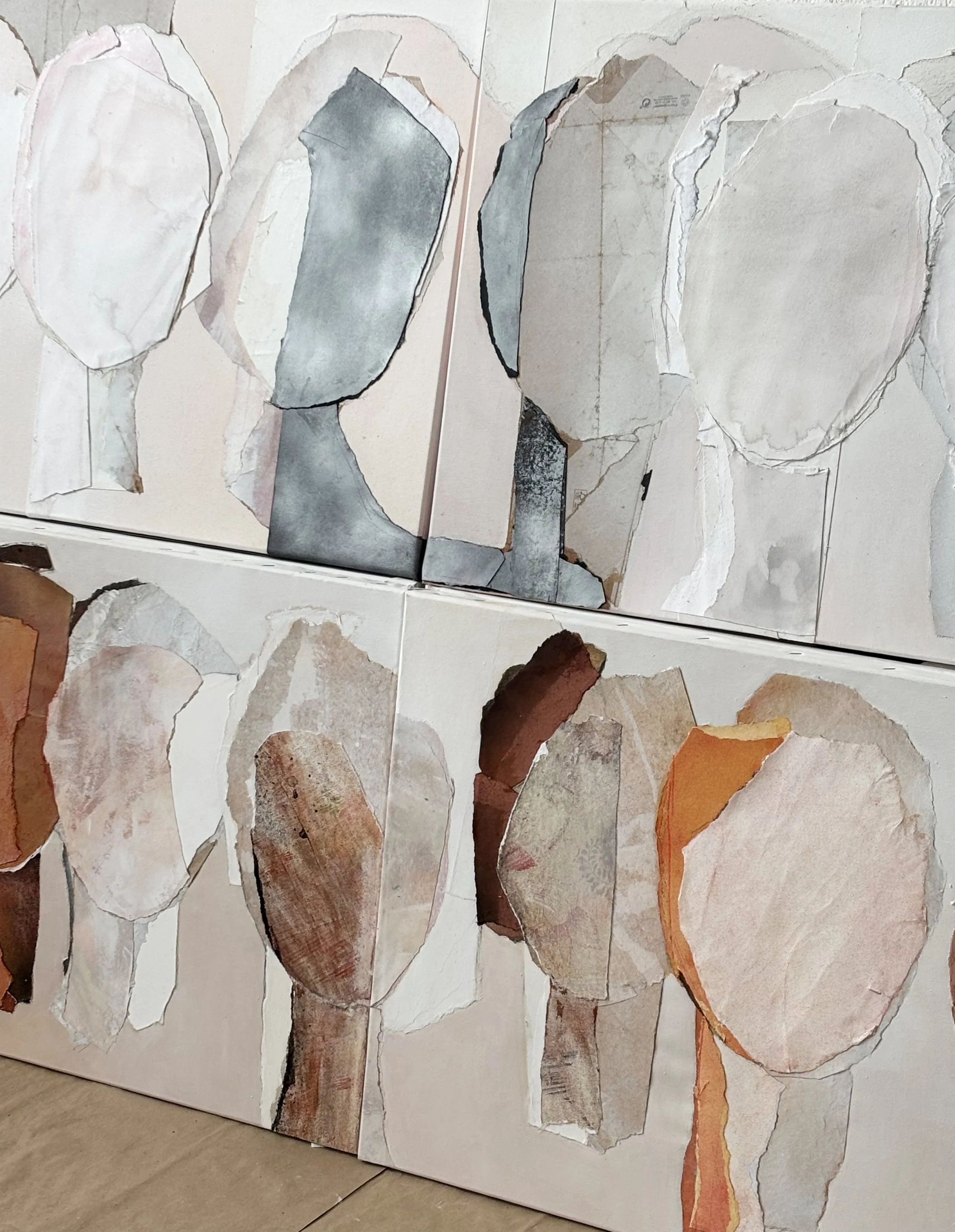 Two abstract paintings side by side, featuring shapes reminiscent of leaves or petals with soft, muted colors including beige, gray, and brown.