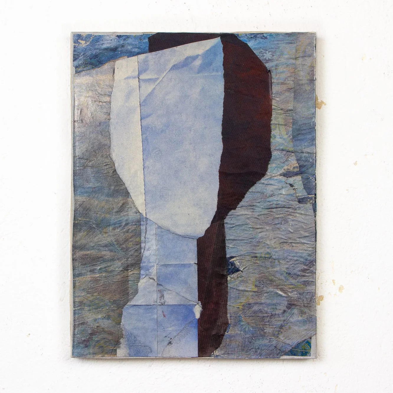 Abstract painting with geometric shapes and earth tones, mounted on a white wall.