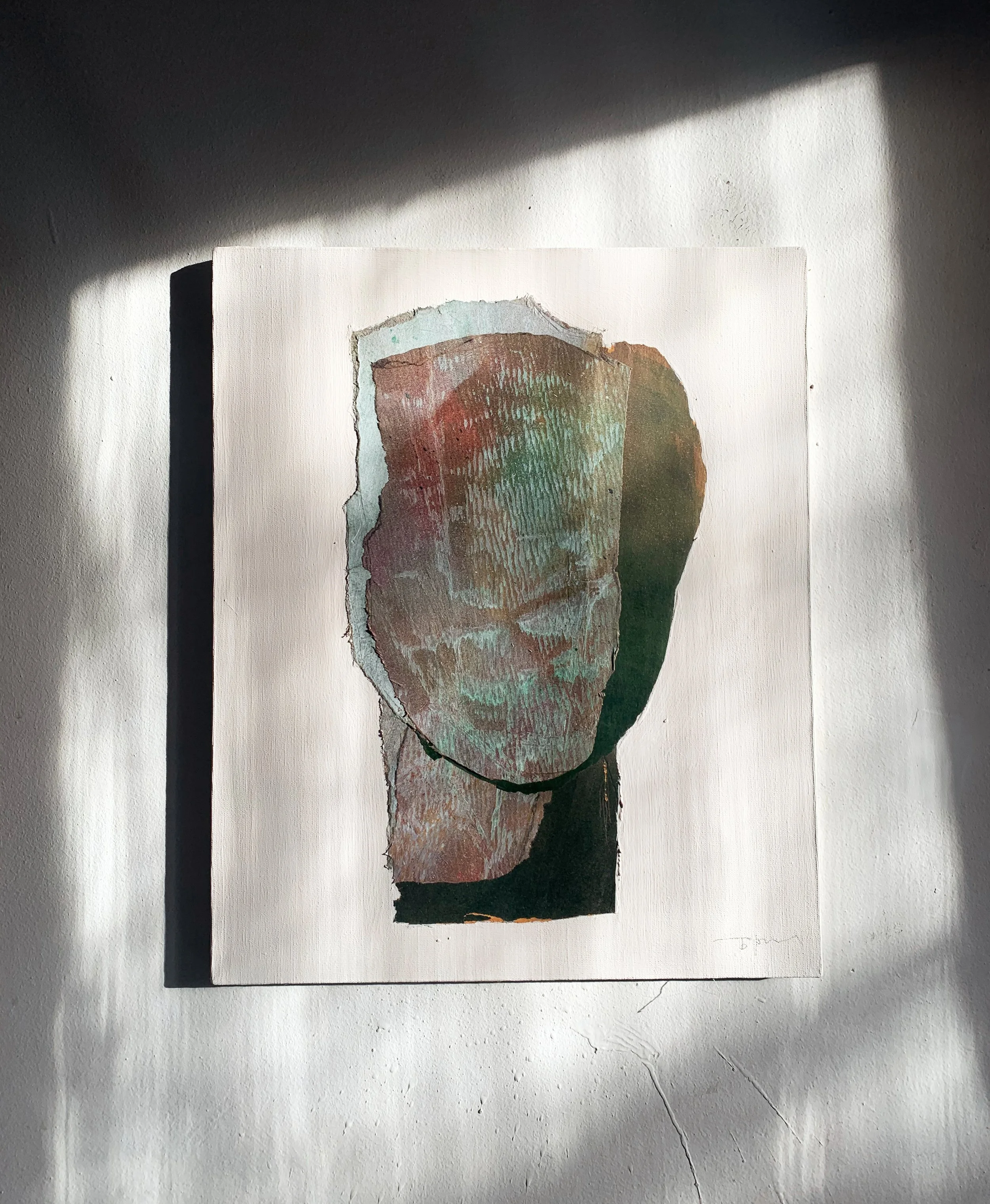 Abstract artwork of a faceless human head with textured, layered colors, mounted on a white wall with shadows cast nearby.