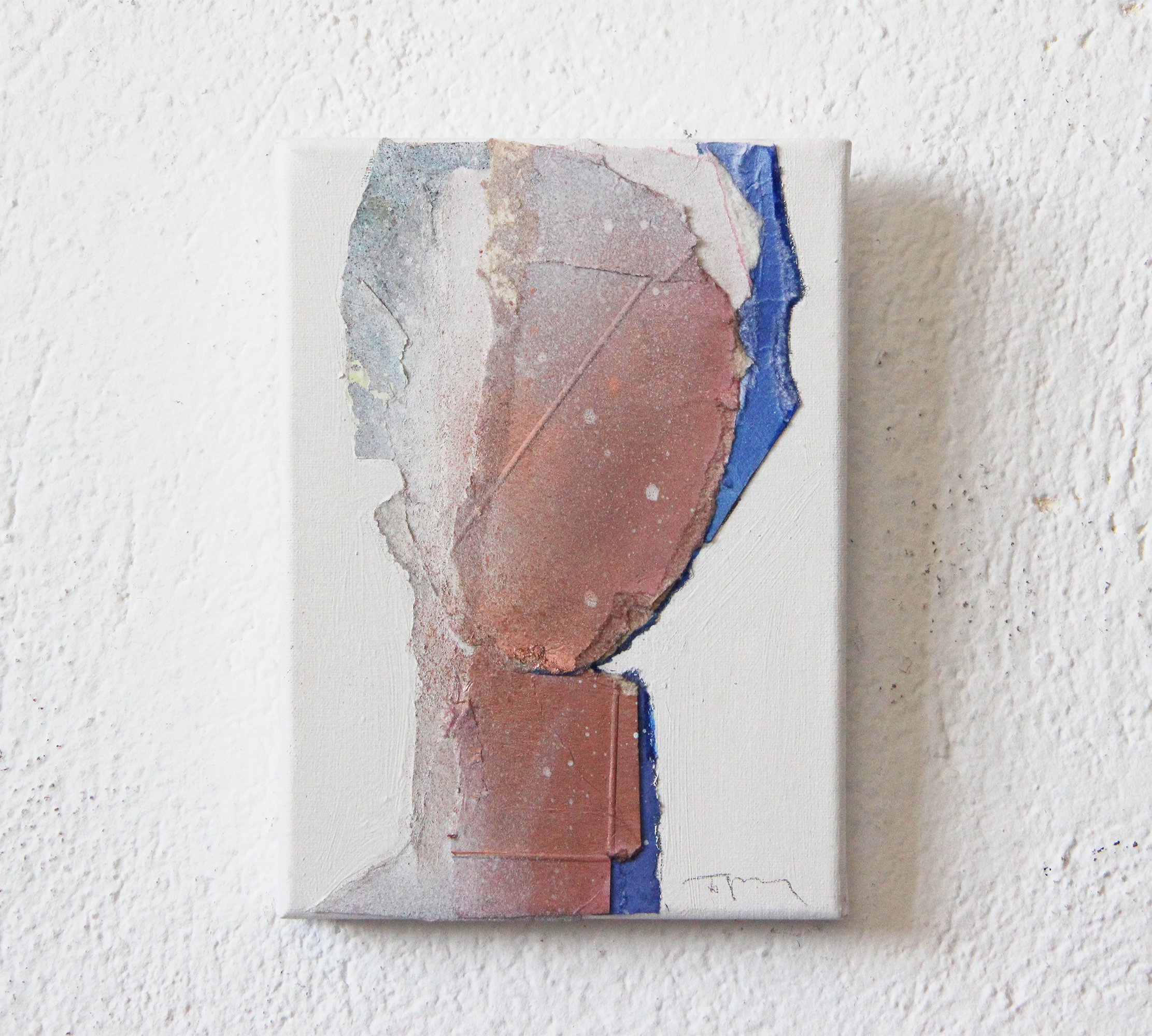 Abstract mixed media artwork with textured surface, rough torn edges, and blue, pink, beige, and gray colors on a white wall.