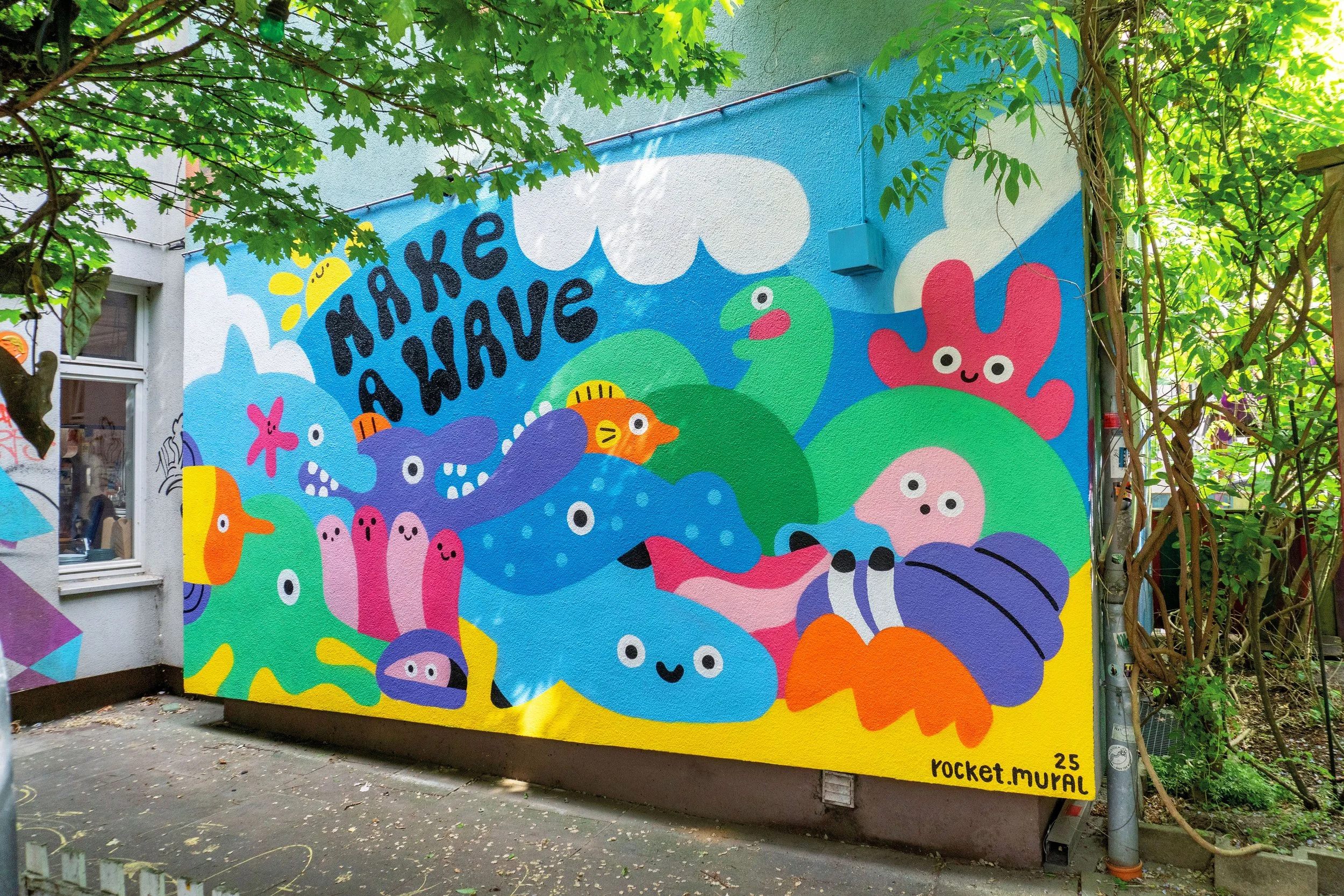 Wandbild mit vielen verschiedenen Meerestieren im Wasser mit dem Schriftzug: Make a wave.
