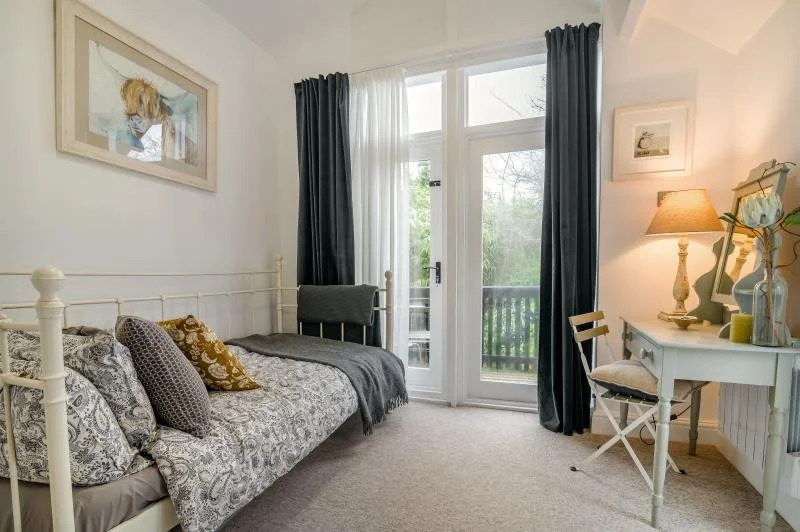 Single bedroom with full-height windows and doors to the veranda, with stairs to the pond secured with top bolts to prevent children from going out.