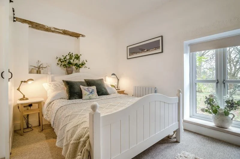 Bedroom Two: Cosy double at the front of the cottage, featuring ample wardrobe space