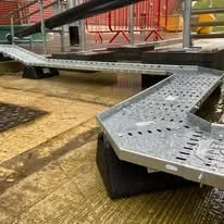 Playground equipment with metal steps and platform on a rubberized ground surface.