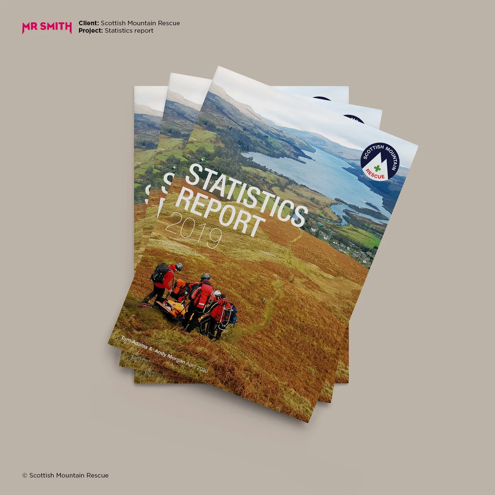 Multiple copies of a Scottish Mountain Rescue statistics report booklet featuring an aerial view of Scottish landscape with mountains, water, and a group of rescue personnel in red gear.