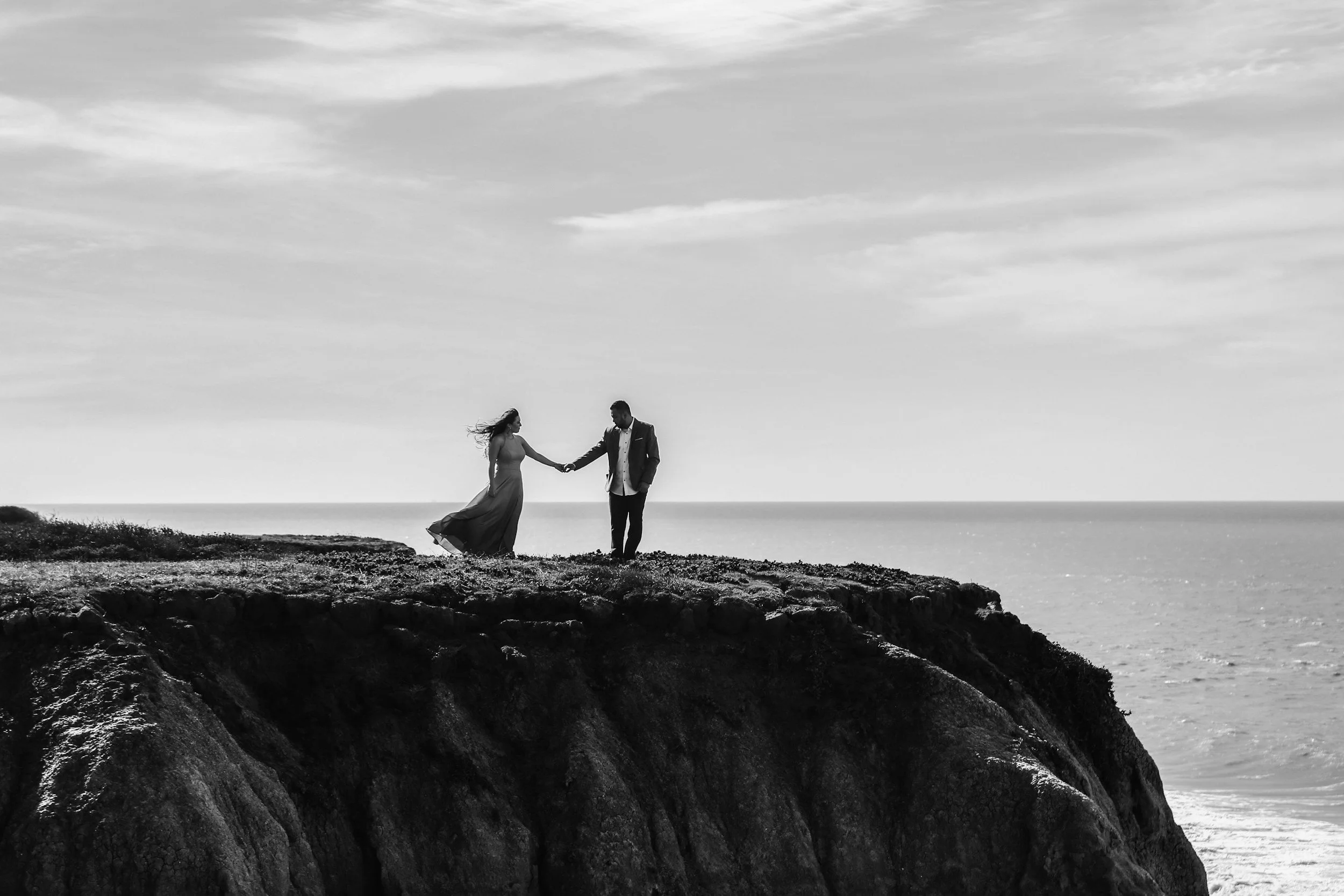 A couple on a clifftop overlooking the sea