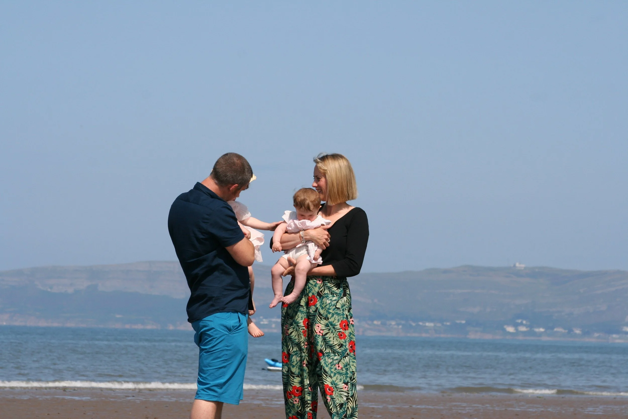 A couple holding a toddler on a beach