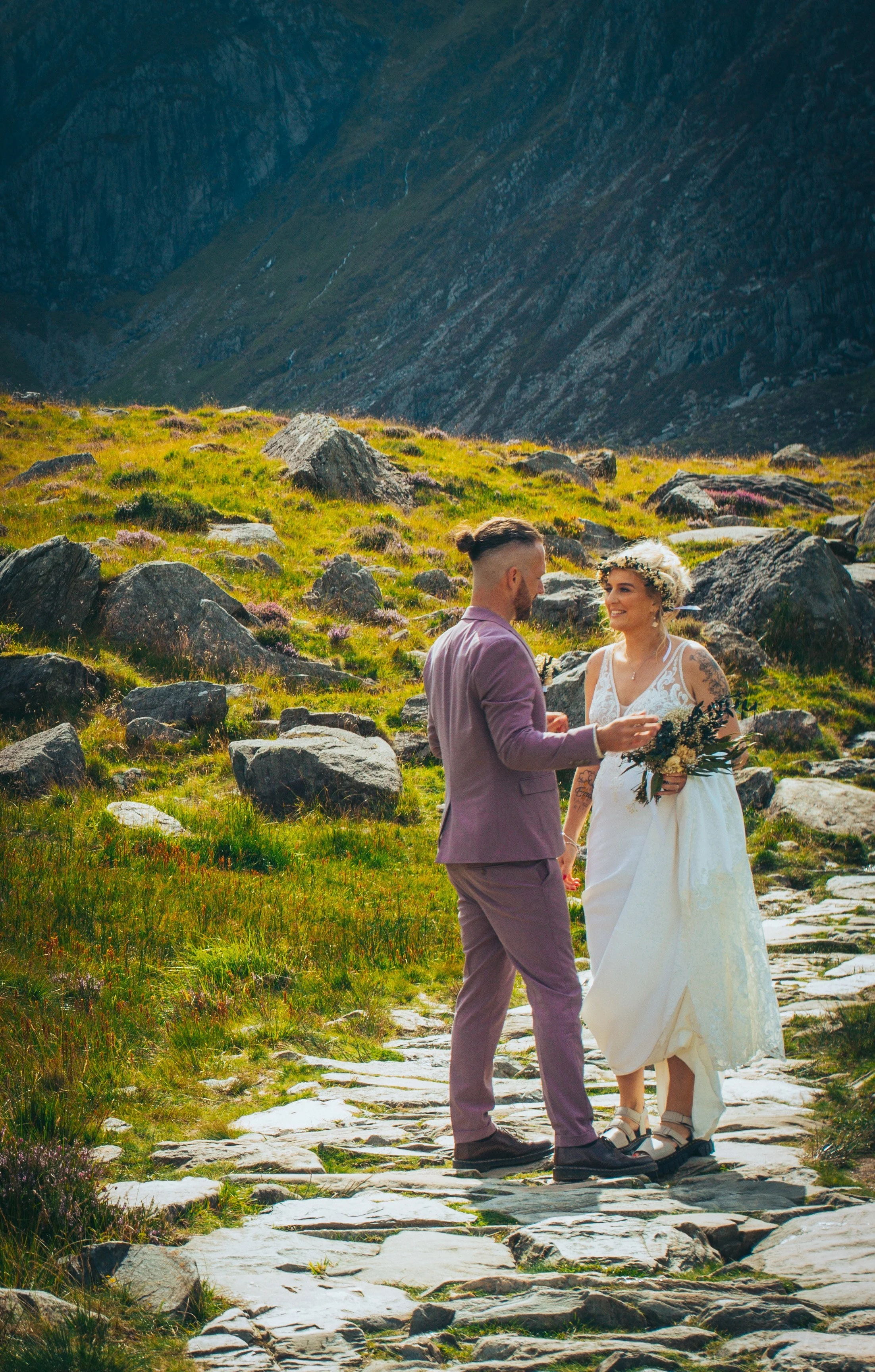 A couple holding hands on a stone mountain path