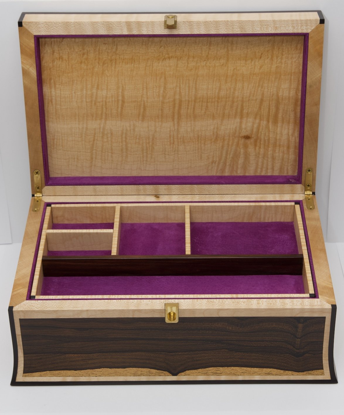 Open wooden jewelry box with purple interior lining and multiple compartments for storage.