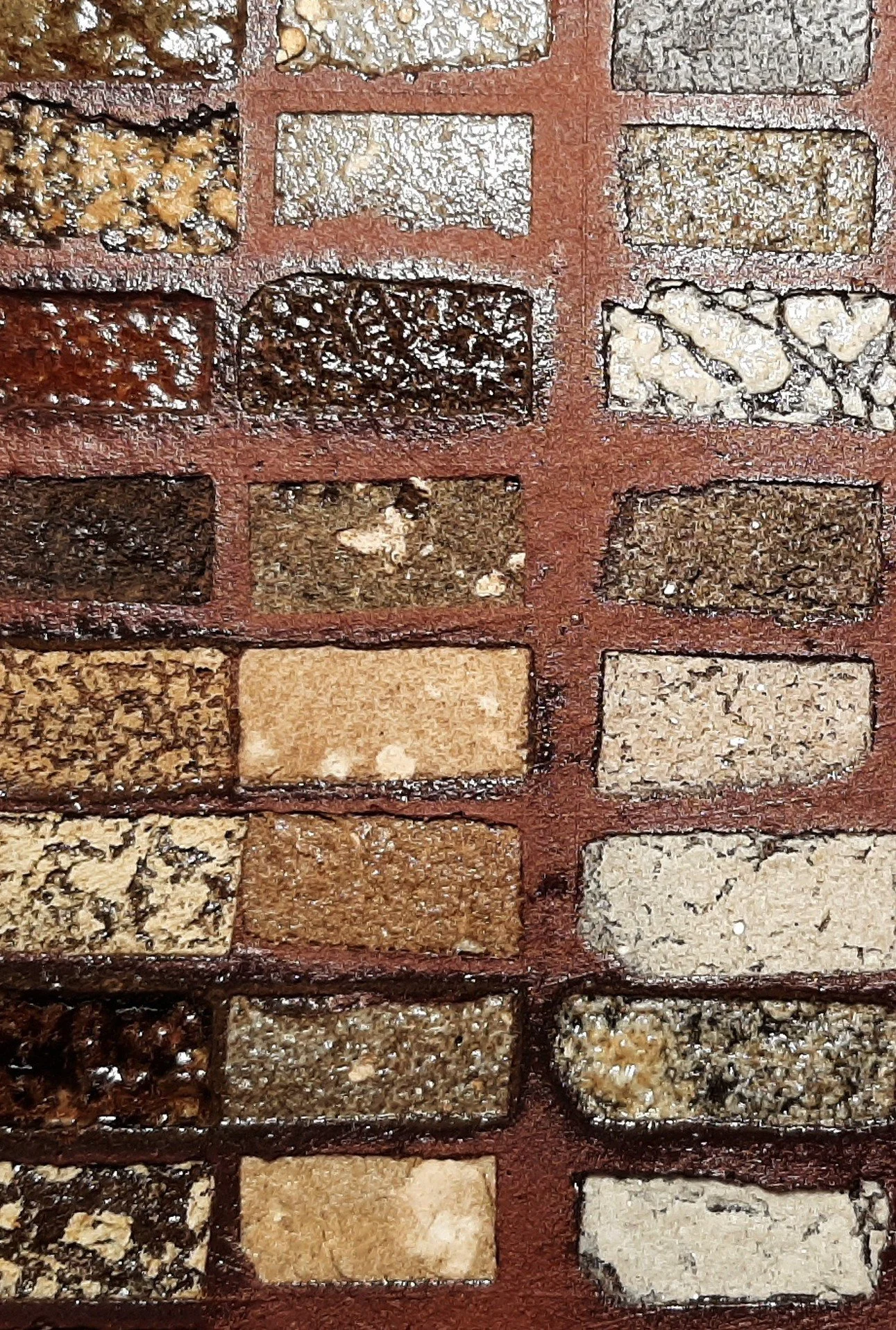 Close-up of a brick wall with bricks of various colors and textures, including tan, red, black, and white, arranged in a grid pattern.