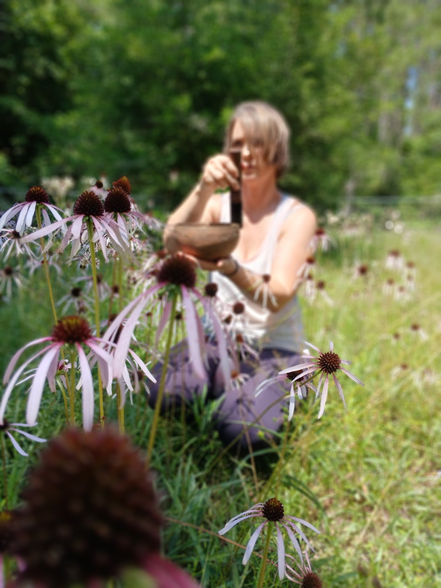 Leah Ann Hill leading a sound-based practice in a natural setting, using singing bowls to support calm, focus, and nervous system balance.