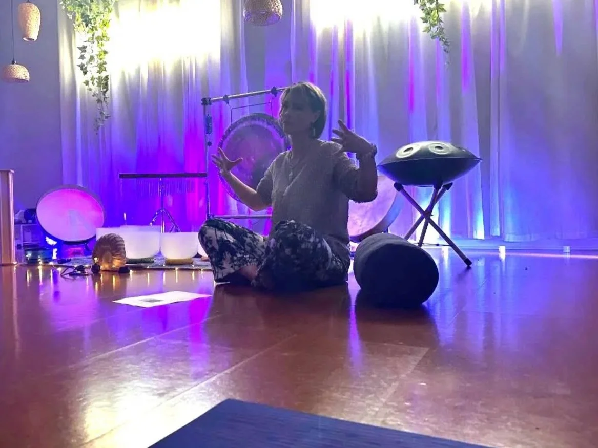 Leah Ann Hill leading a guided sound and speaking experience using crystal singing bowls to support group connection and nervous system regulation.
