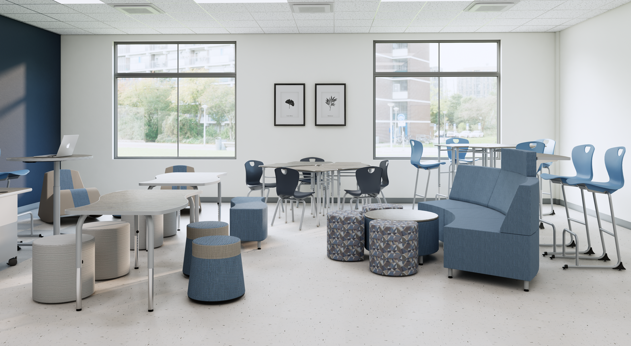 Bright lounge or common area with large windows, white walls, and modern furniture including blue and beige chairs, ottomans, and a curved sofa. Framed black-and-white leaf prints hang on the wall.