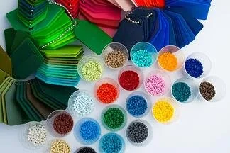 Colorful fabric swatches and small containers with beads or sequins in various colors