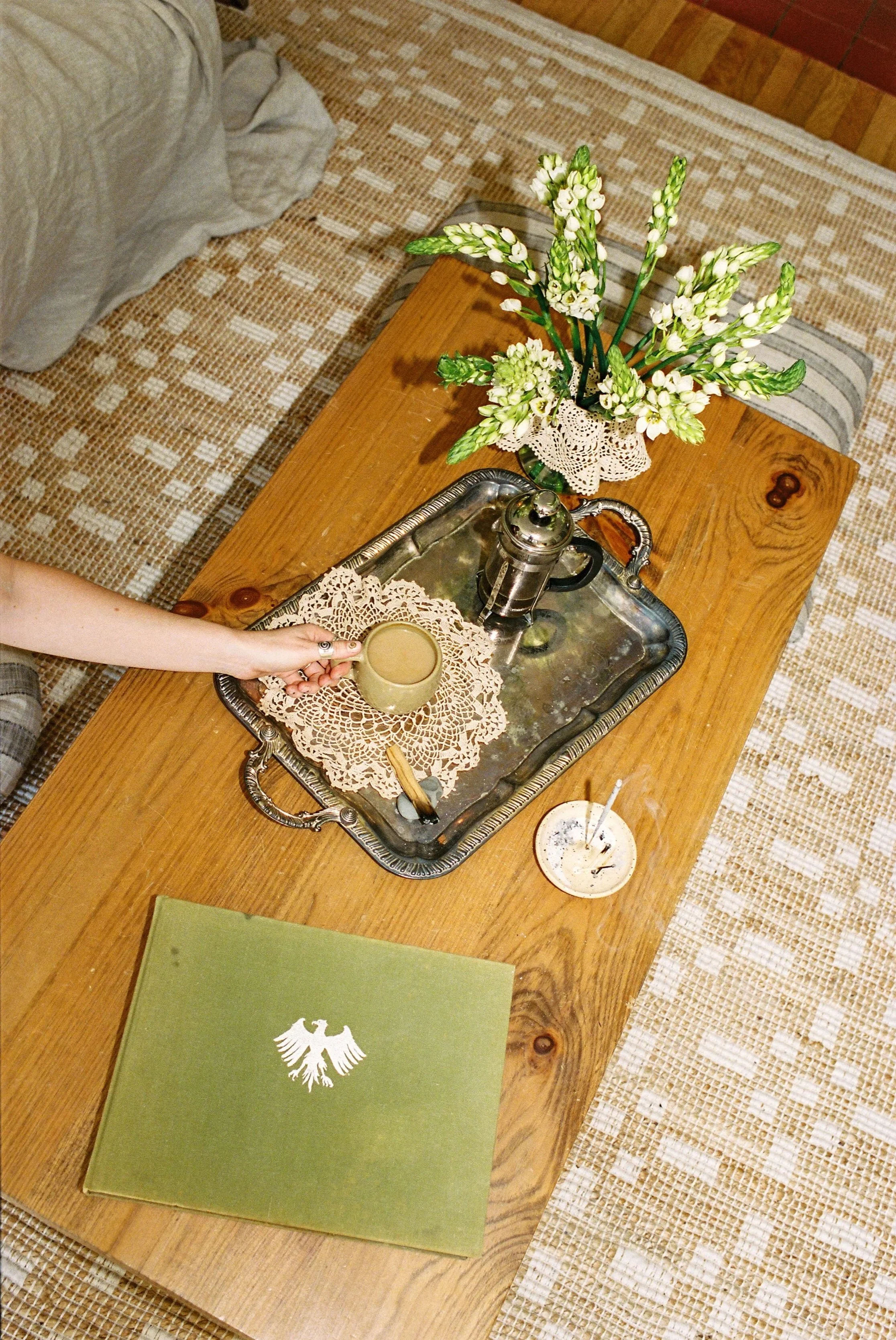 Coffee table decor. Woman holding a coffee cup enjoying her home.