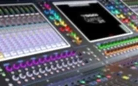 Close-up of audio mixing console with colorful buttons and sliders.