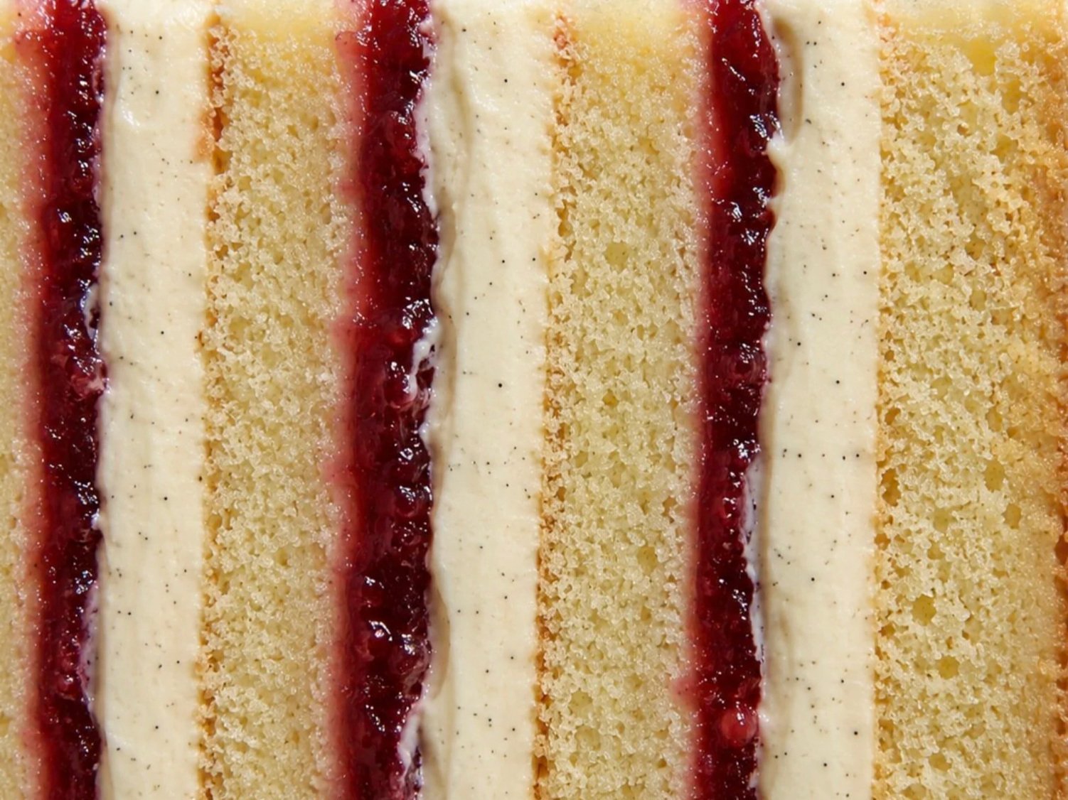 Cross-section of vanilla sponge layered with jam and vanilla buttercream