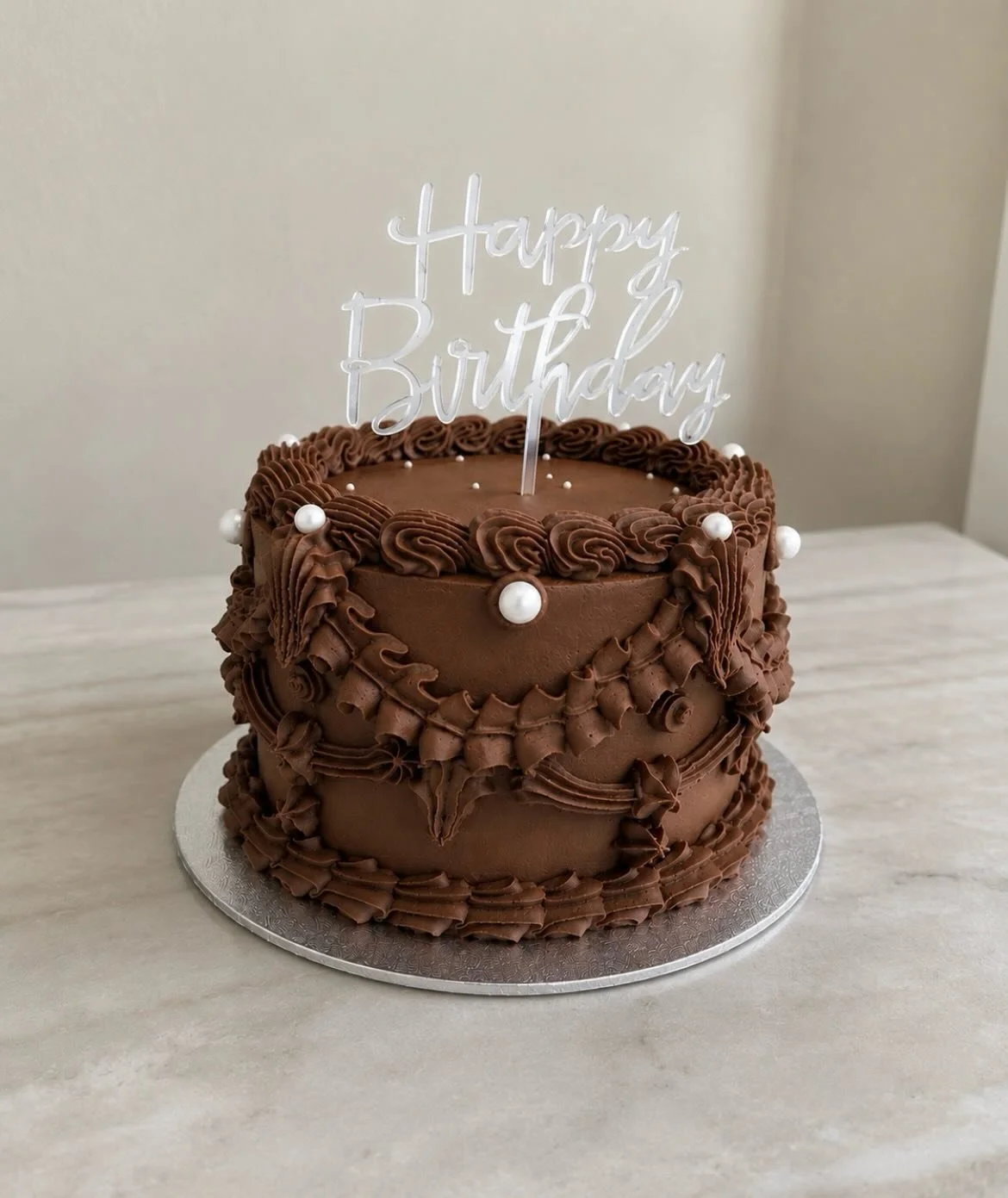 Layers of rich chocolate fudge cake, filled with silky chocolate ganache and milk chocolate throughout 🤎 Finished with vintage piping for a special birthday celebration ✨🎂 #cakes #celebrationcake #vintagecake #suffolk #woodbridge