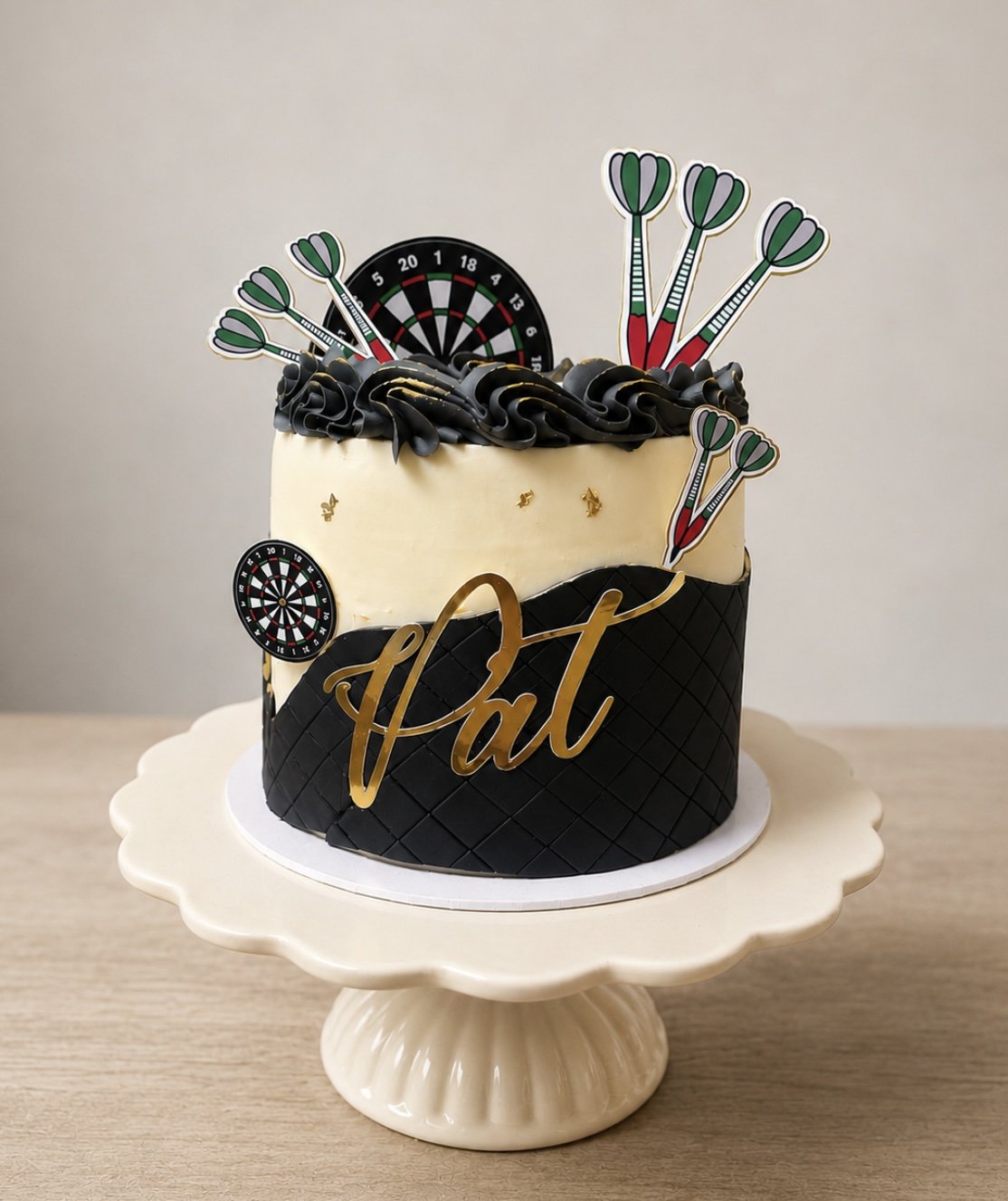 Darts-themed celebration cake with a personalised gold name topper