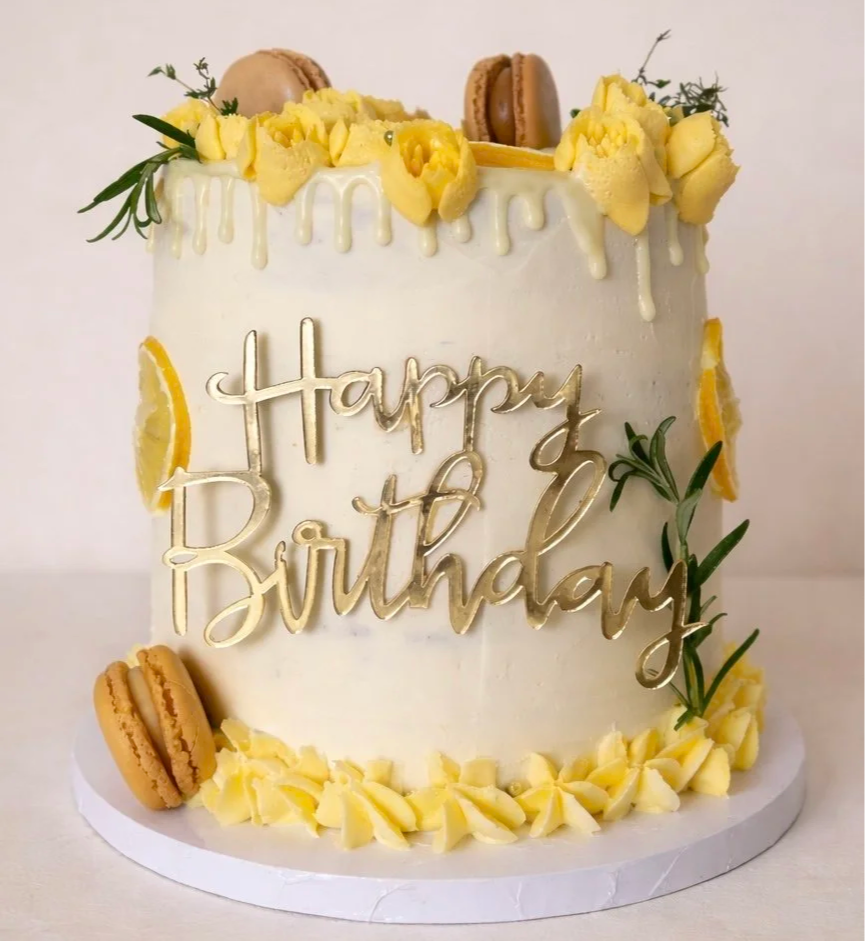 Buttercream birthday cake with yellow flowers, macarons and a gold Happy Birthday topper, Woodbridge, Suffolk