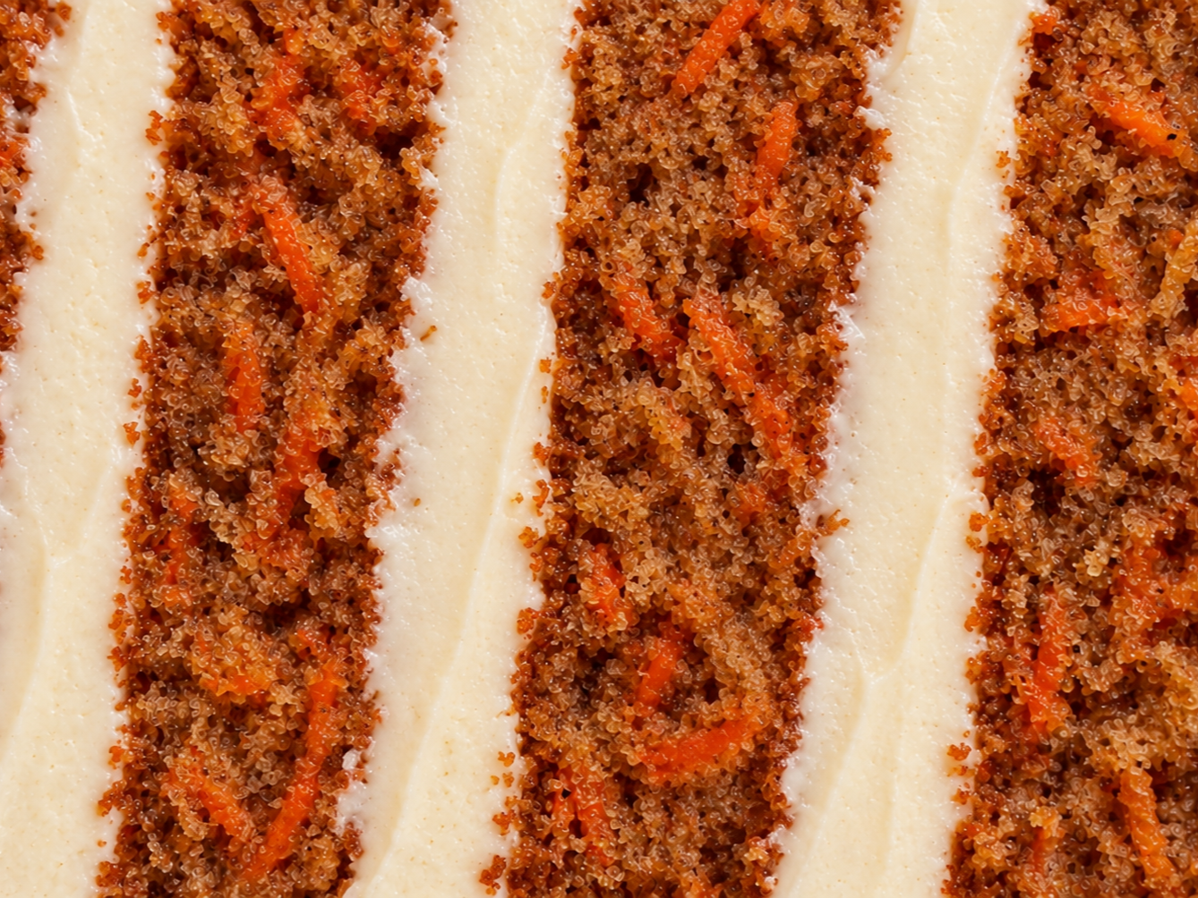 Cross-section of carrot cake layered with cream cheese icing