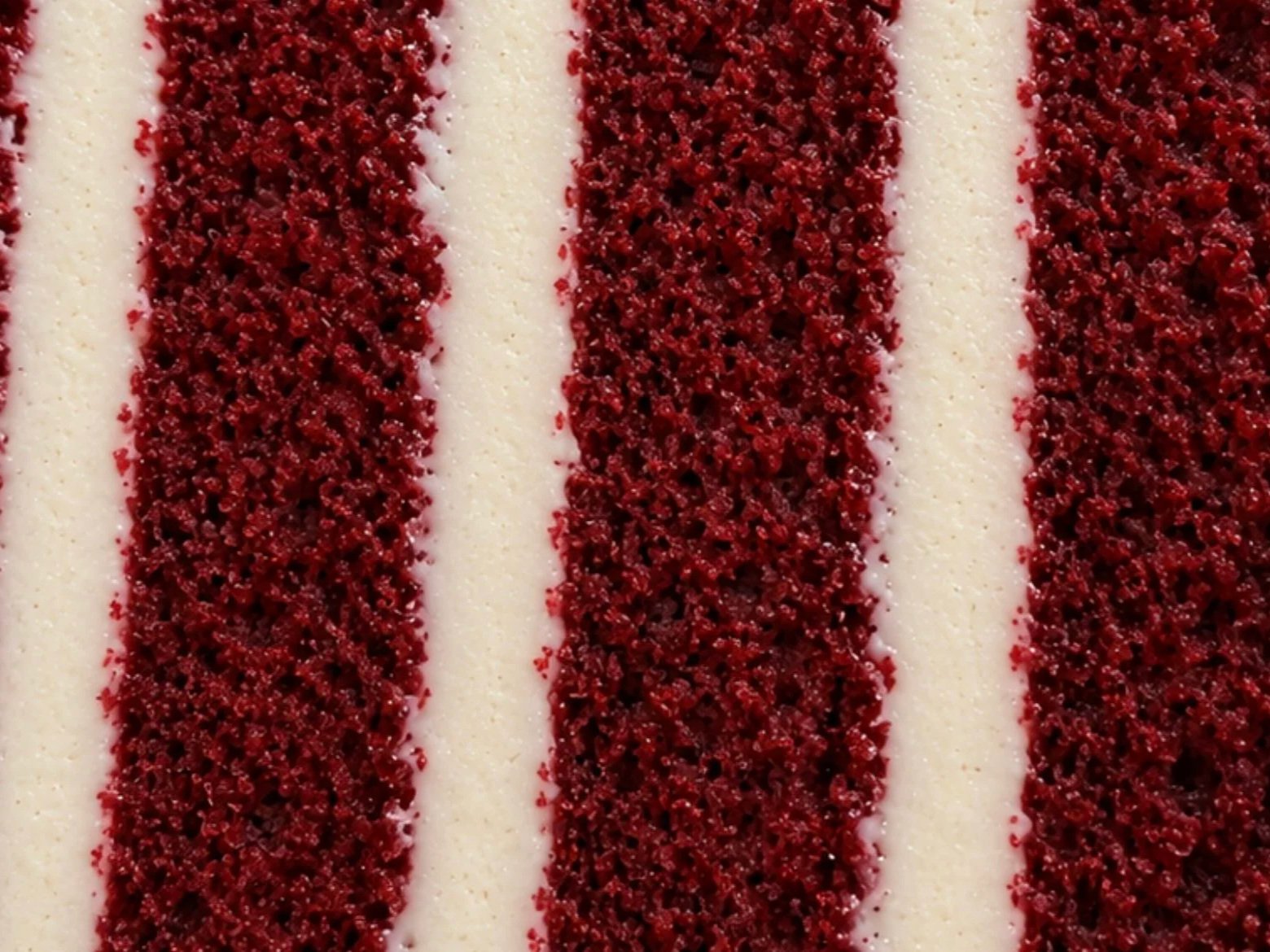 Cross-section of red velvet sponge layered with cream cheese icing