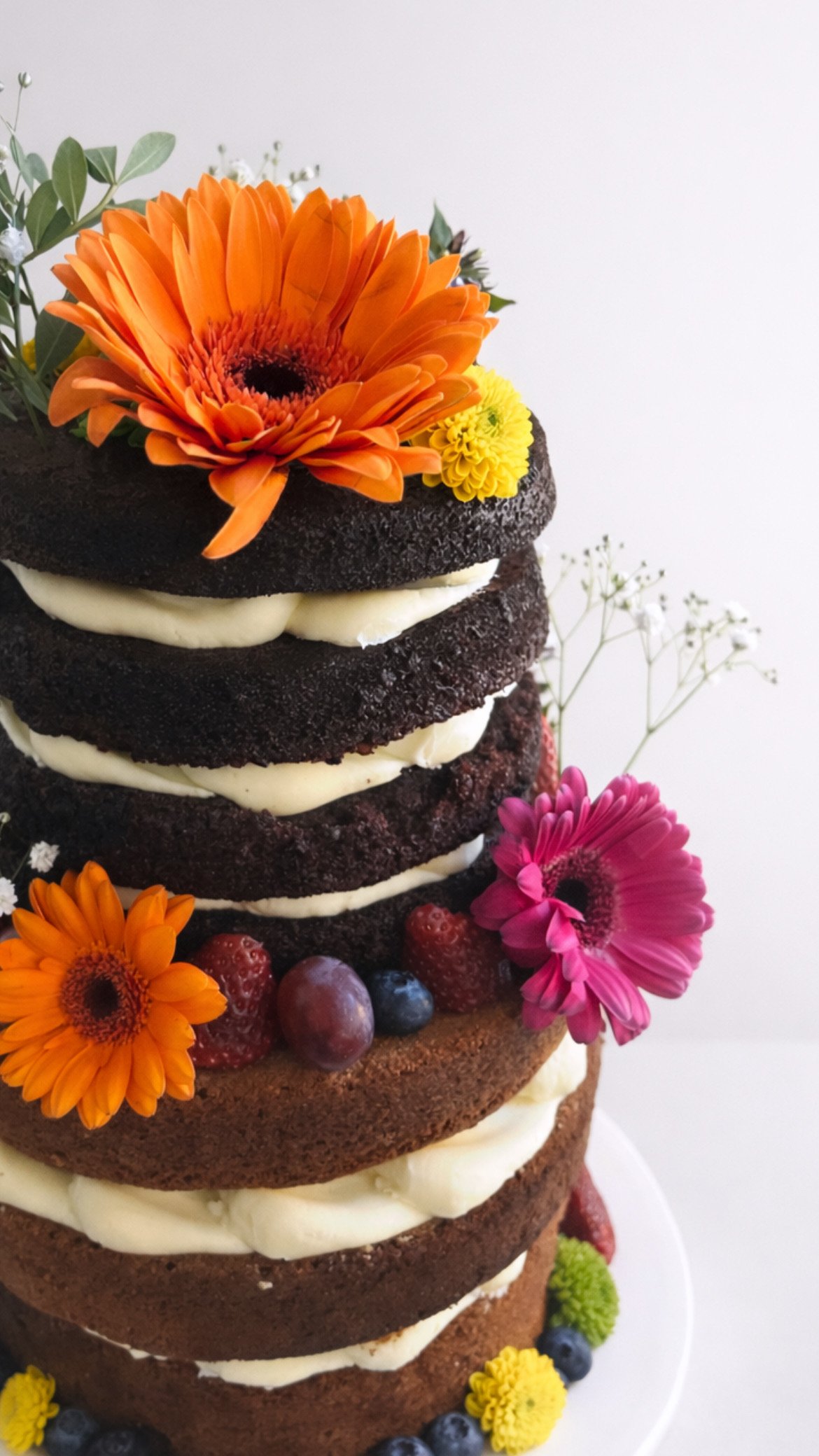 Naked layer cake with fresh flowers and berries