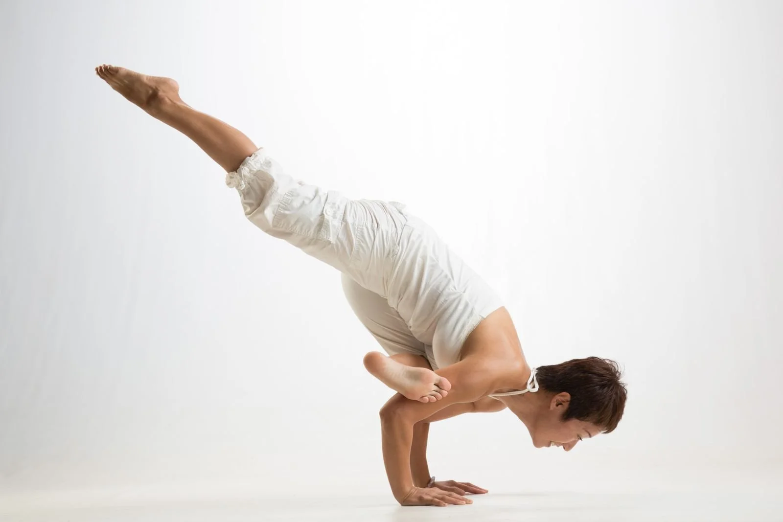 A person is performing a yoga pose called a handstand with their legs extended upward while balancing on their hands.