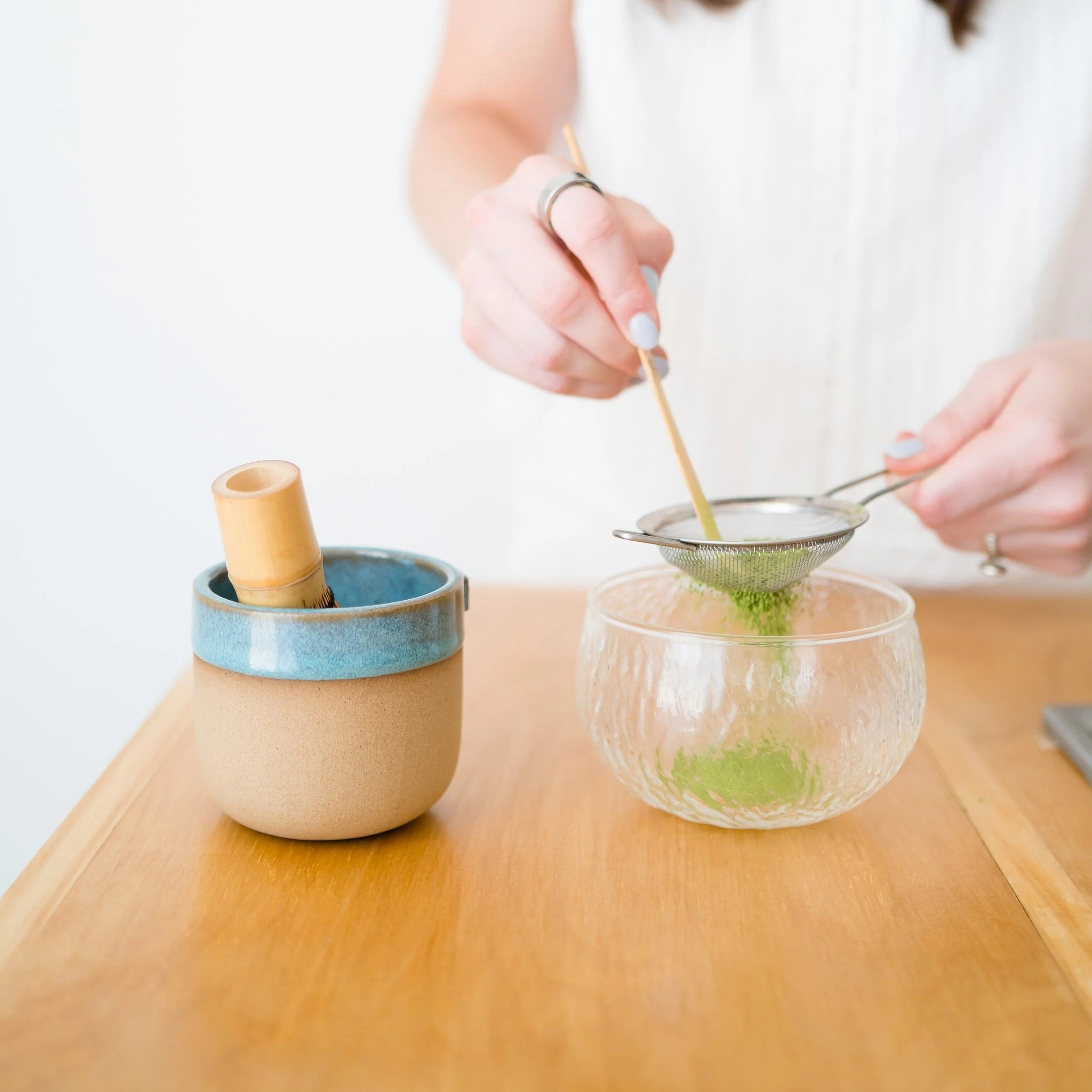 Matcha being sifted on a coffee cart for cafe mendoza dallas coffee cart catering with a woman with hands and painted nails