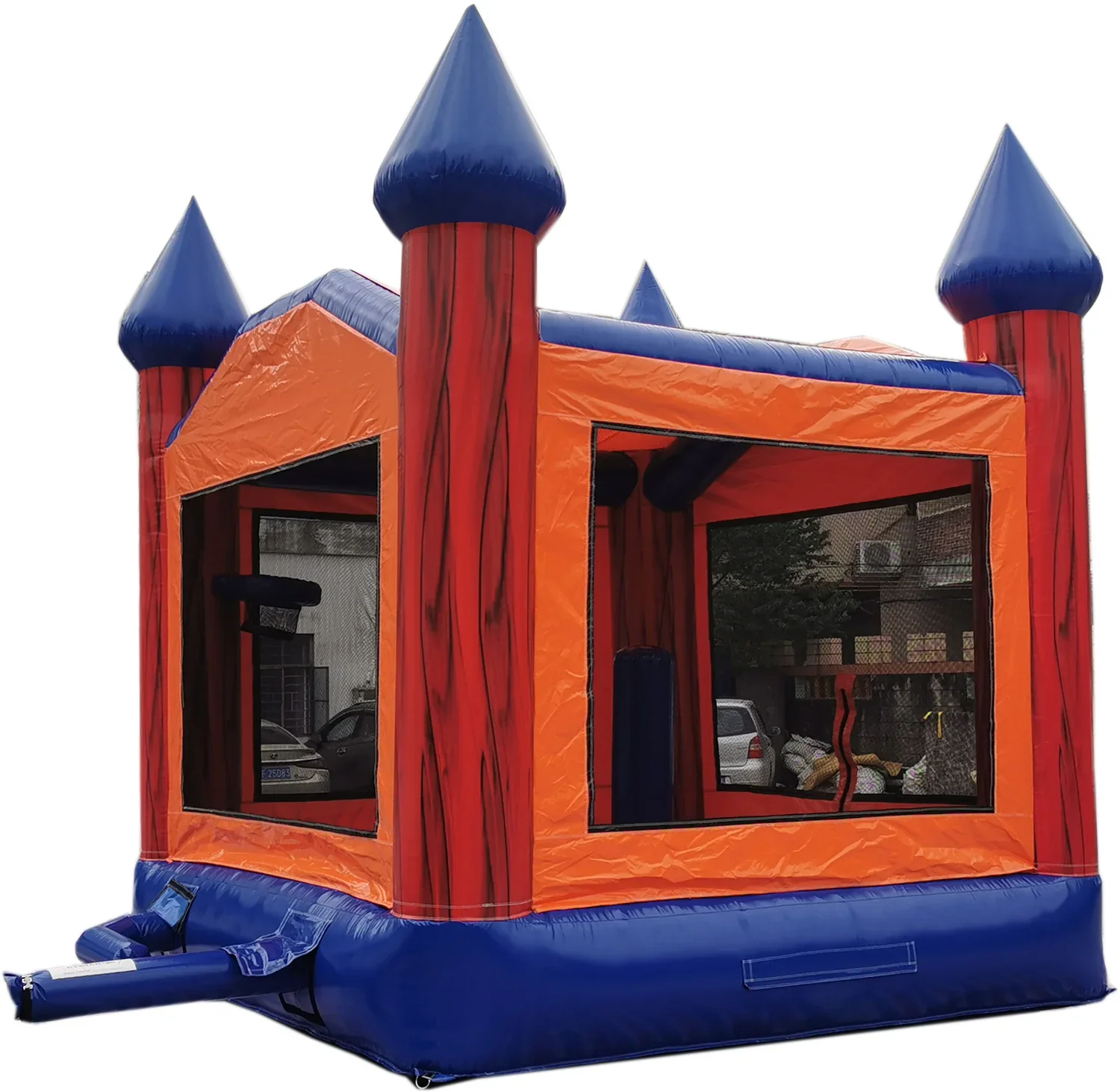 Colorful bounce house with orange walls, blue turrets, and a blue inflatable slide, set outdoors on a cloudy day.