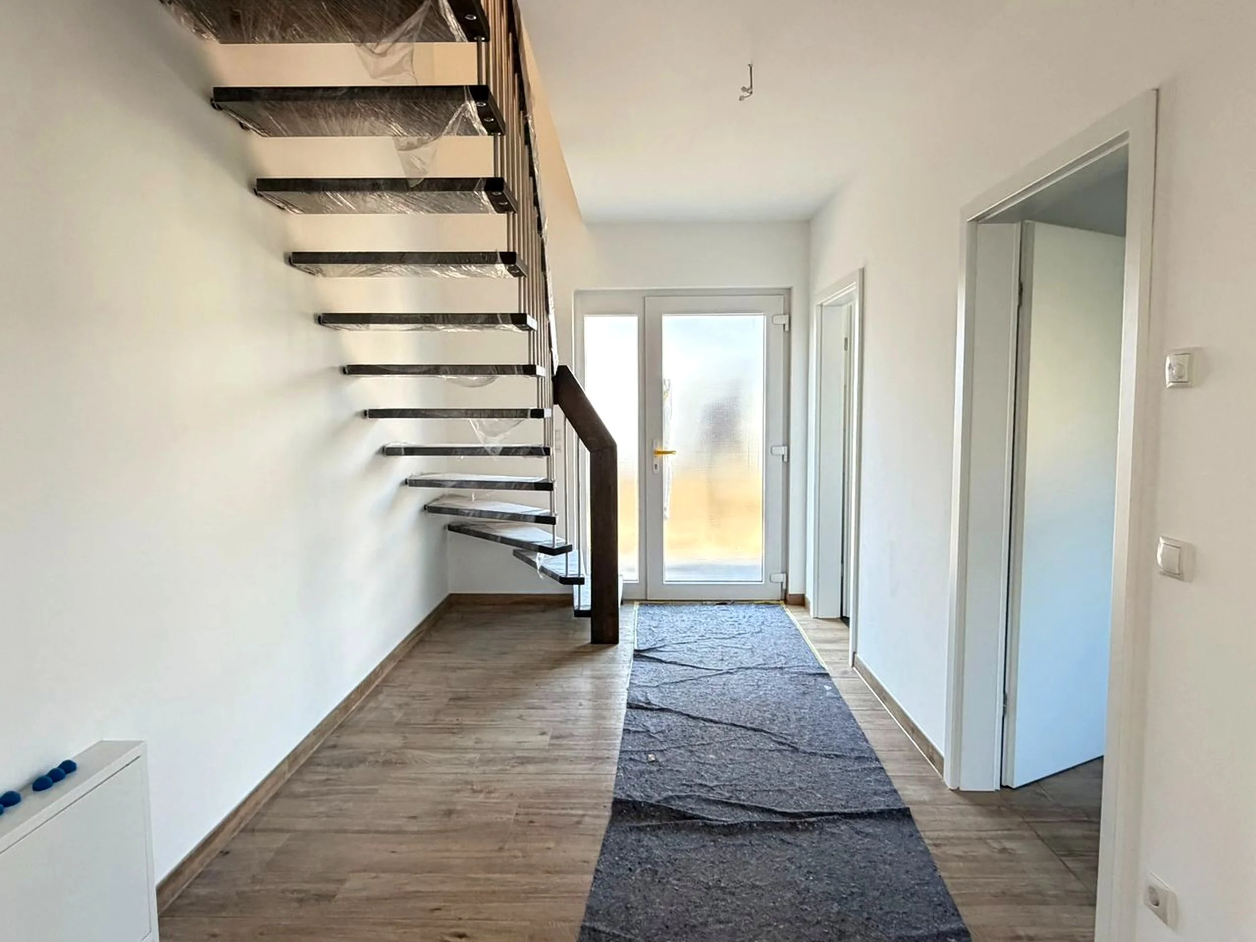 Hausflur, Blick aus dem Wohnzimmer; rechts befinden sich der Hauswirtschaftsraum und das Gästebad