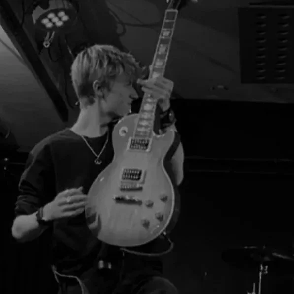 Young man playing an electric guitar in a music studio.