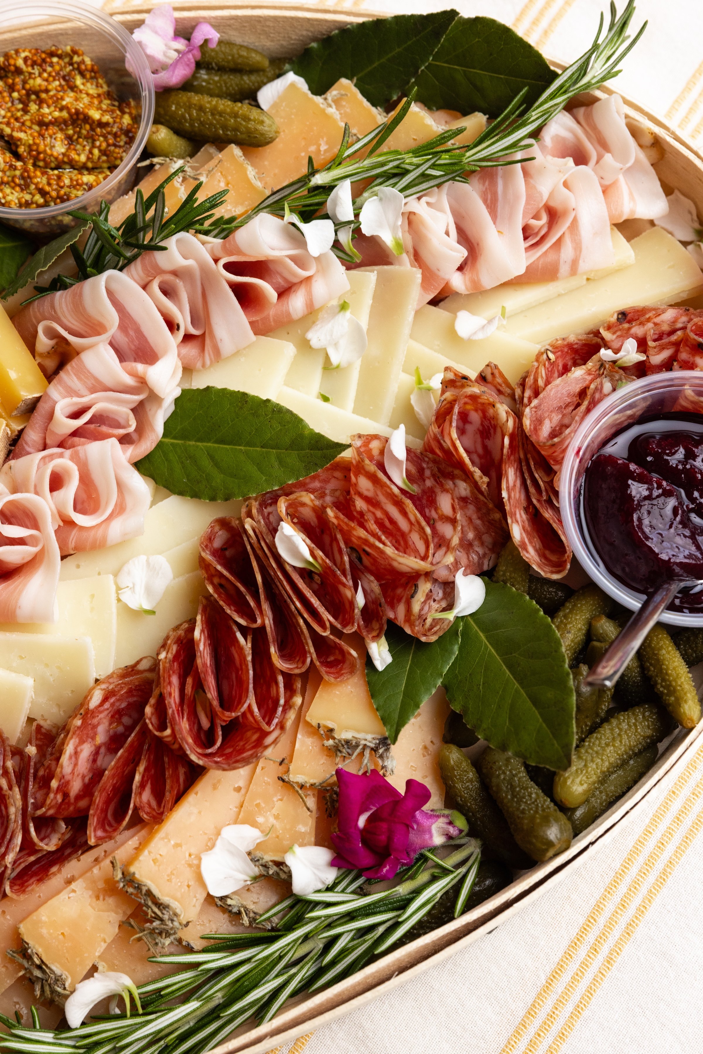 Close-up of an All Together Now cheese and charcuterie board with artisan cheeses, cured meats, preserves and cornichons.