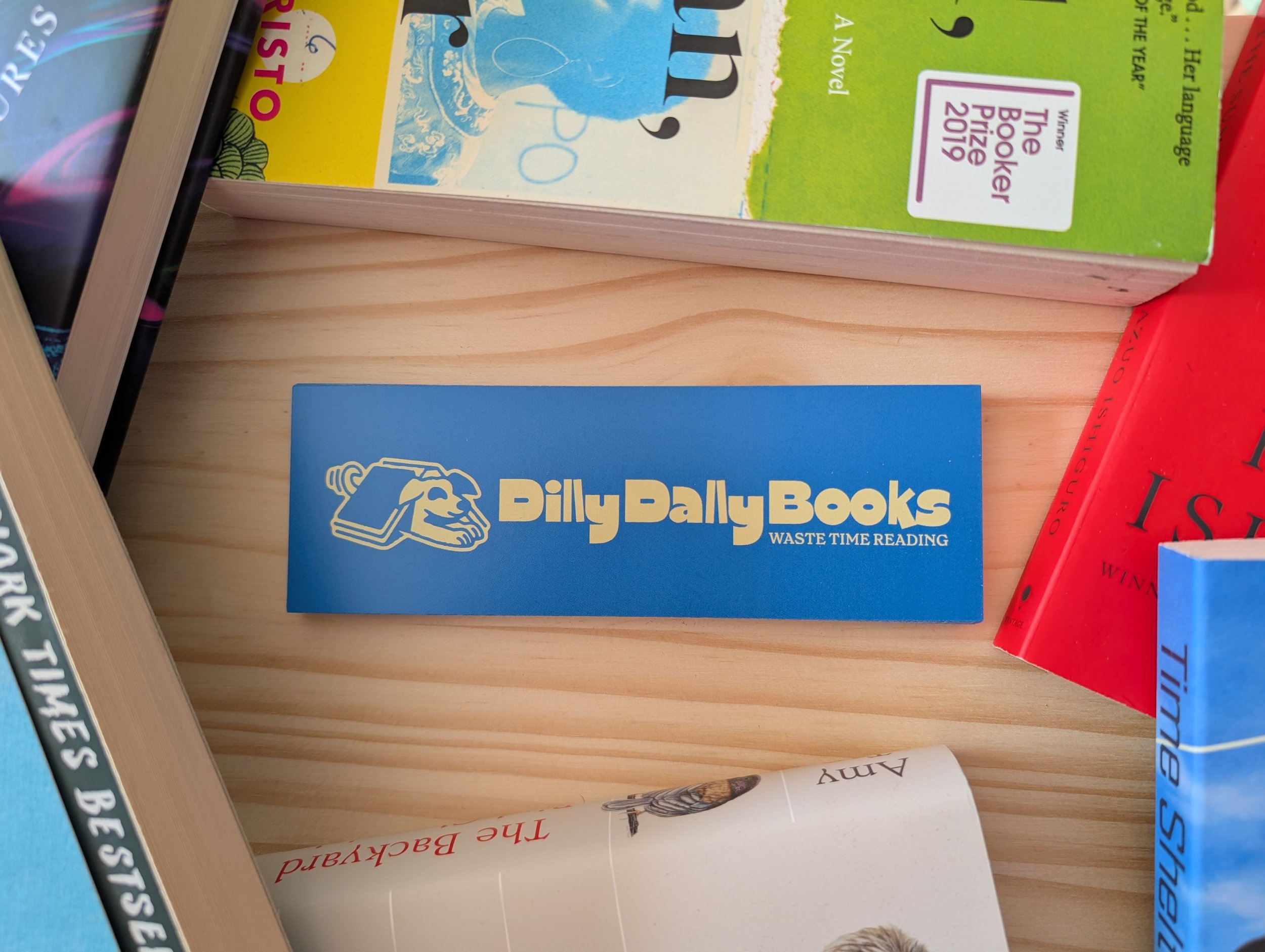A bookmark on a wooden shelf surrounded by the best books