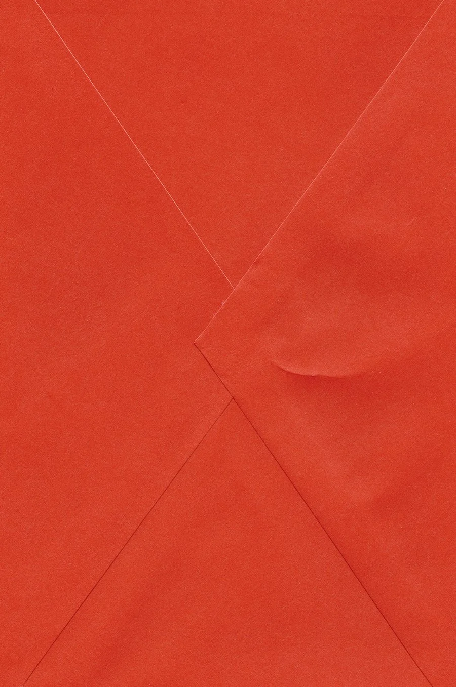 Close-up of an orange cardboard box with visible seams and a torn section.