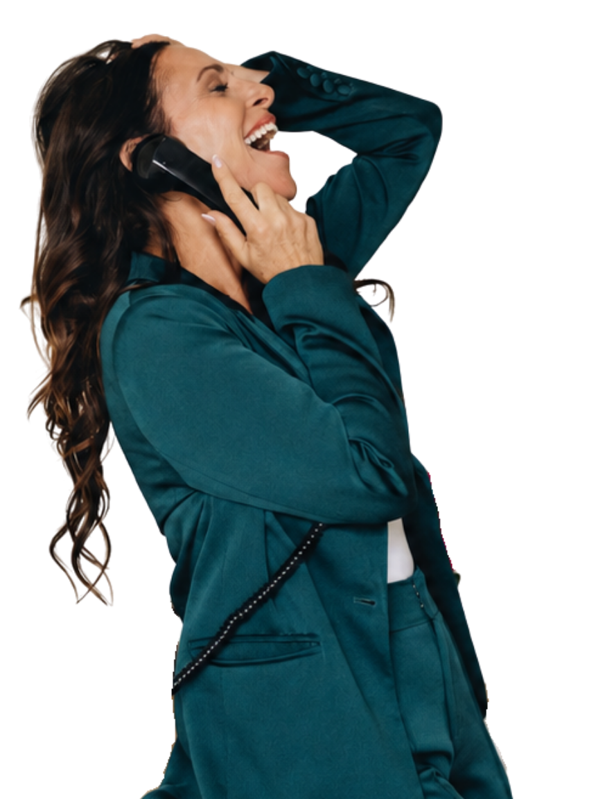 Woman in teal suit talking on a phone, smiling with her eyes closed and head tilted back.