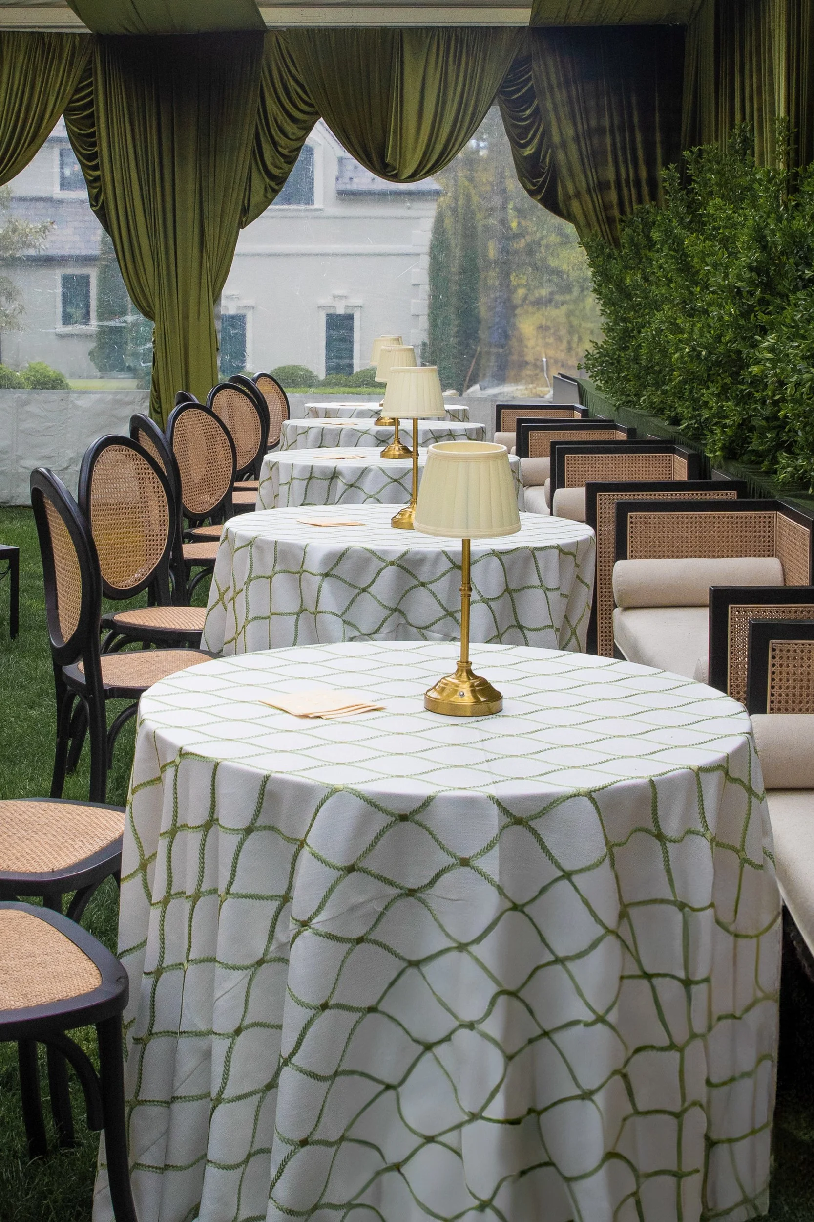 Intimate seating with patterned linens and soft lamp lighting brought warmth and sophistication to the tented lounge environment.