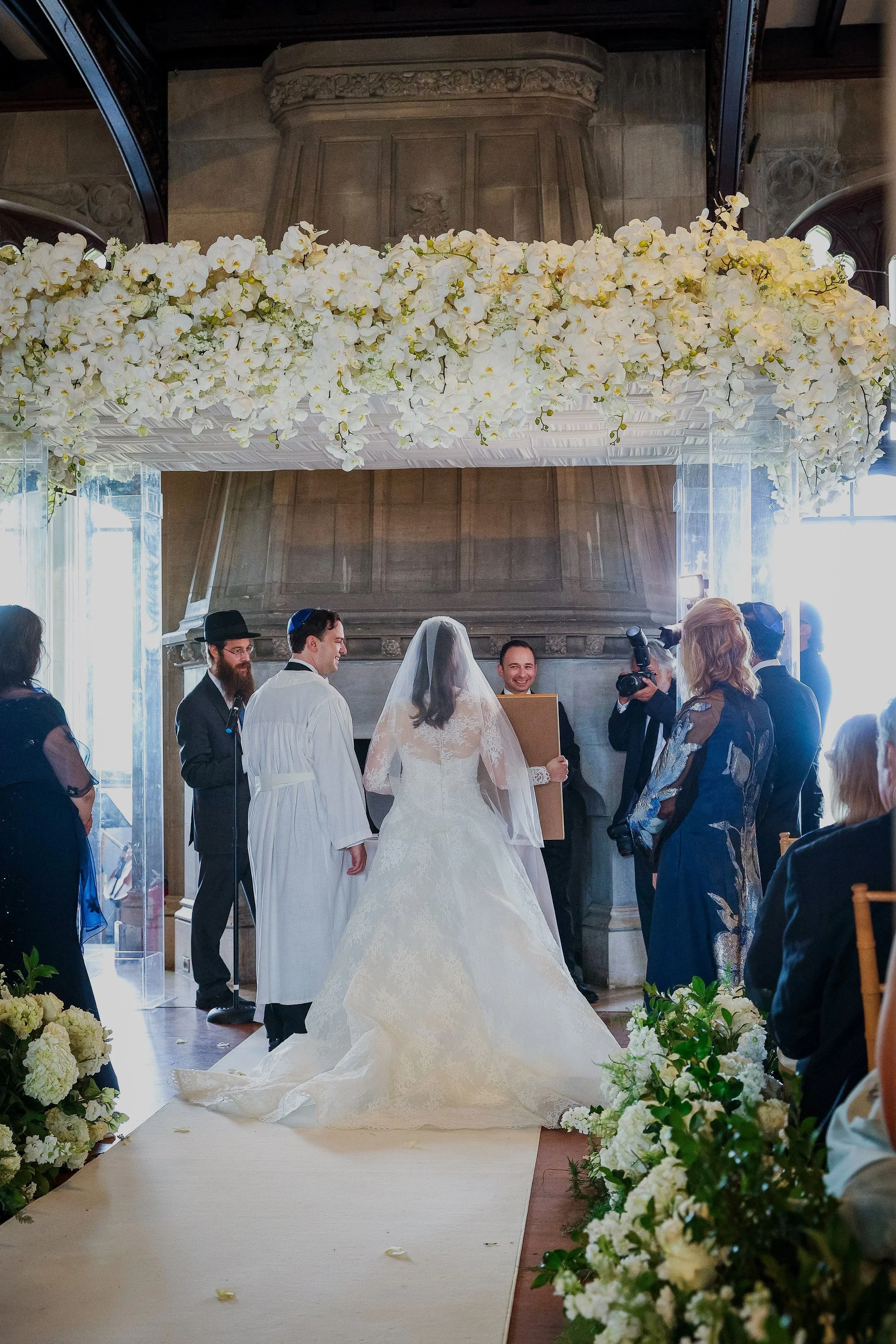 Jewish wedding ceremony at Hempstead House with floral chuppah and aisle lined with white flowers