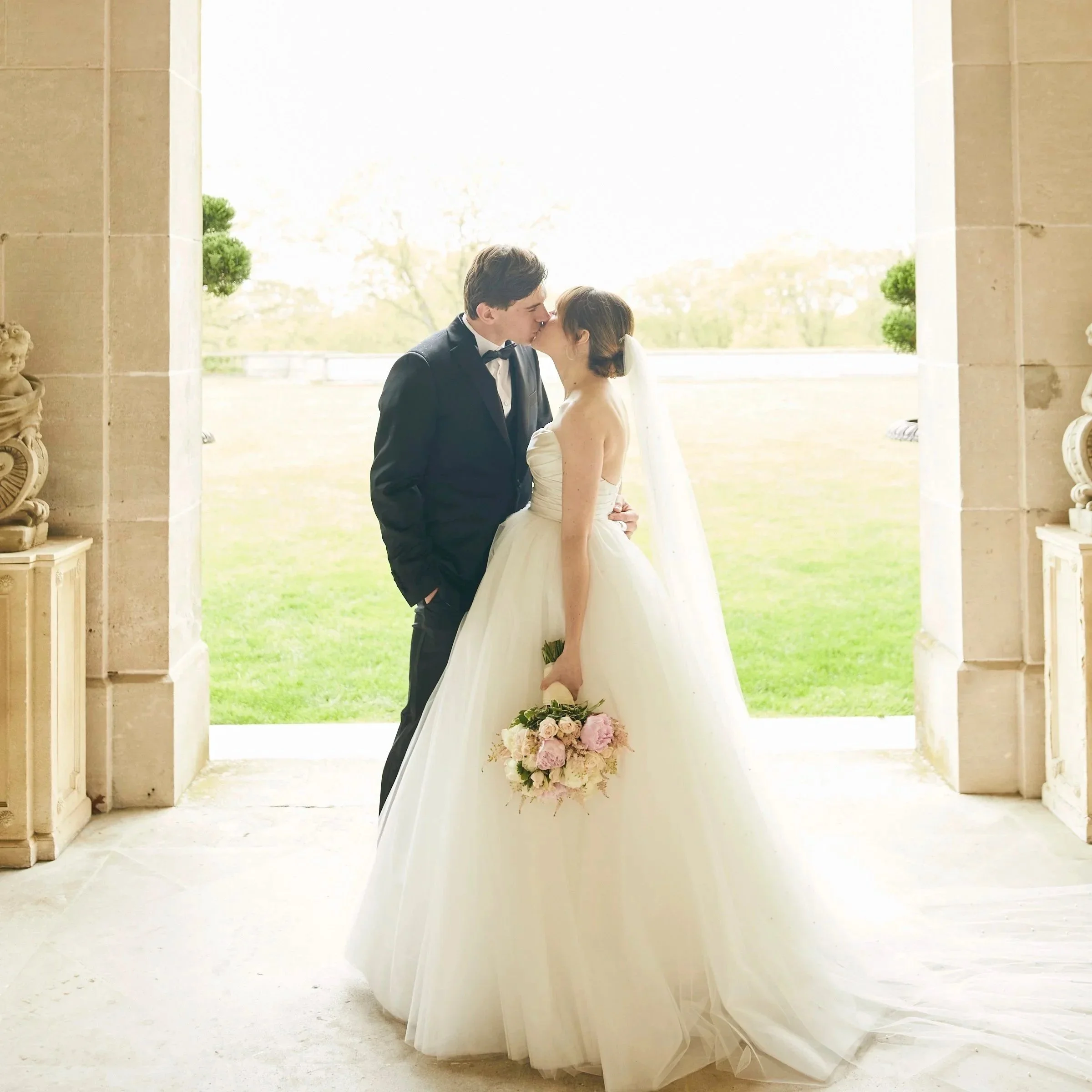Bride and Groom share a kiss on the great lawn of Oheka Castle