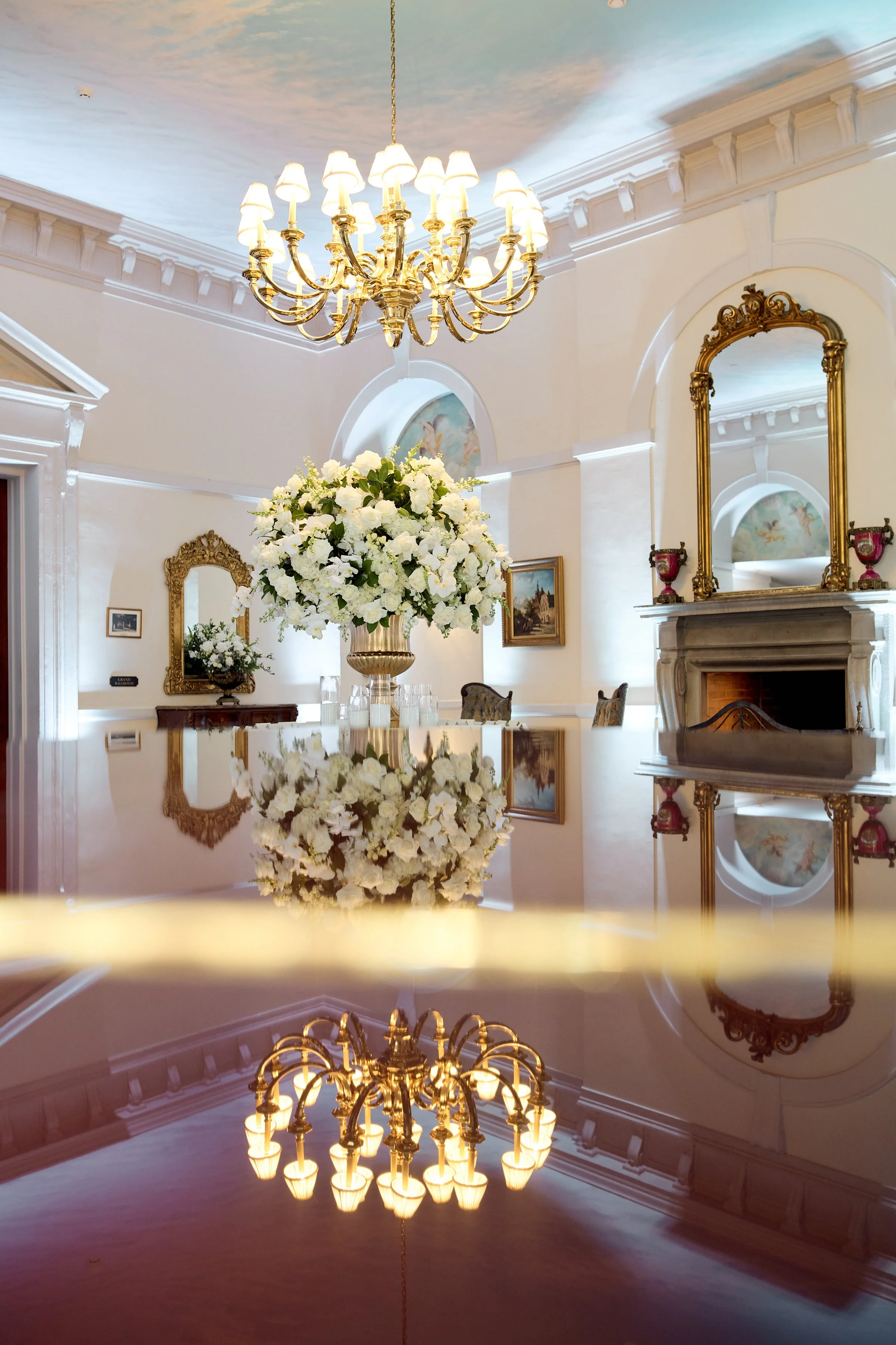 Upper foyer with the escort card table centerpiece reflecting off of the grand piano.