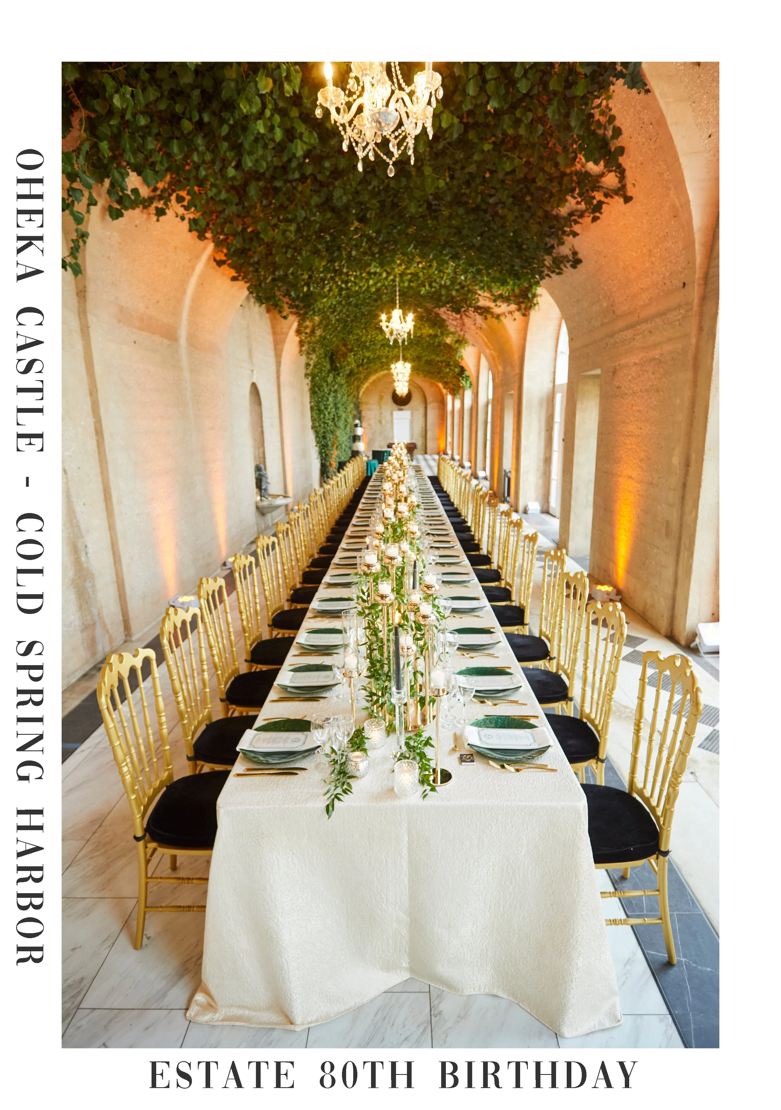A long rectangular banquet table set for a celebration in an elegant hall with high arched ceilings, large windows, and chandeliers. The table is decorated with candles, greenery, and tableware, and is surrounded by golden chairs. The hall has warm lighting and lush greenery is hanging from the ceiling. The event is for someone celebrating their 80th birthday.