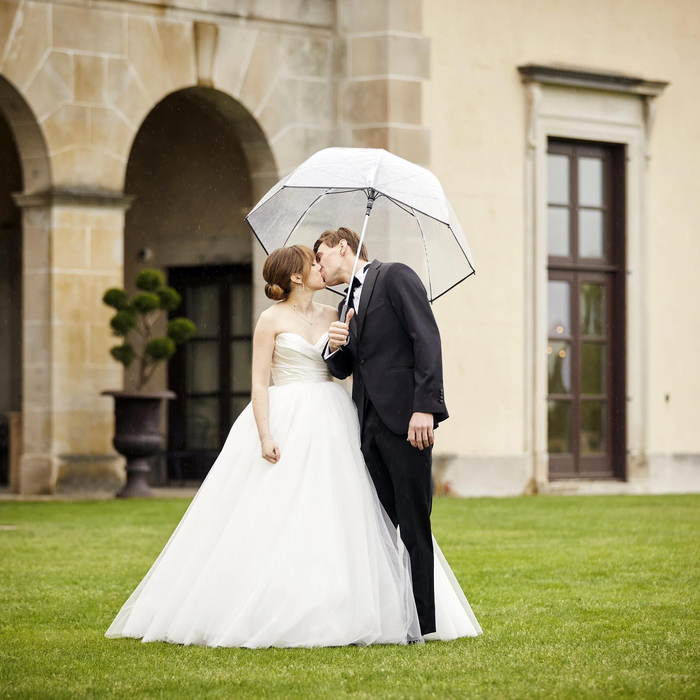Bride and Groom Portrait, kissing in the rain at Oheka Castle