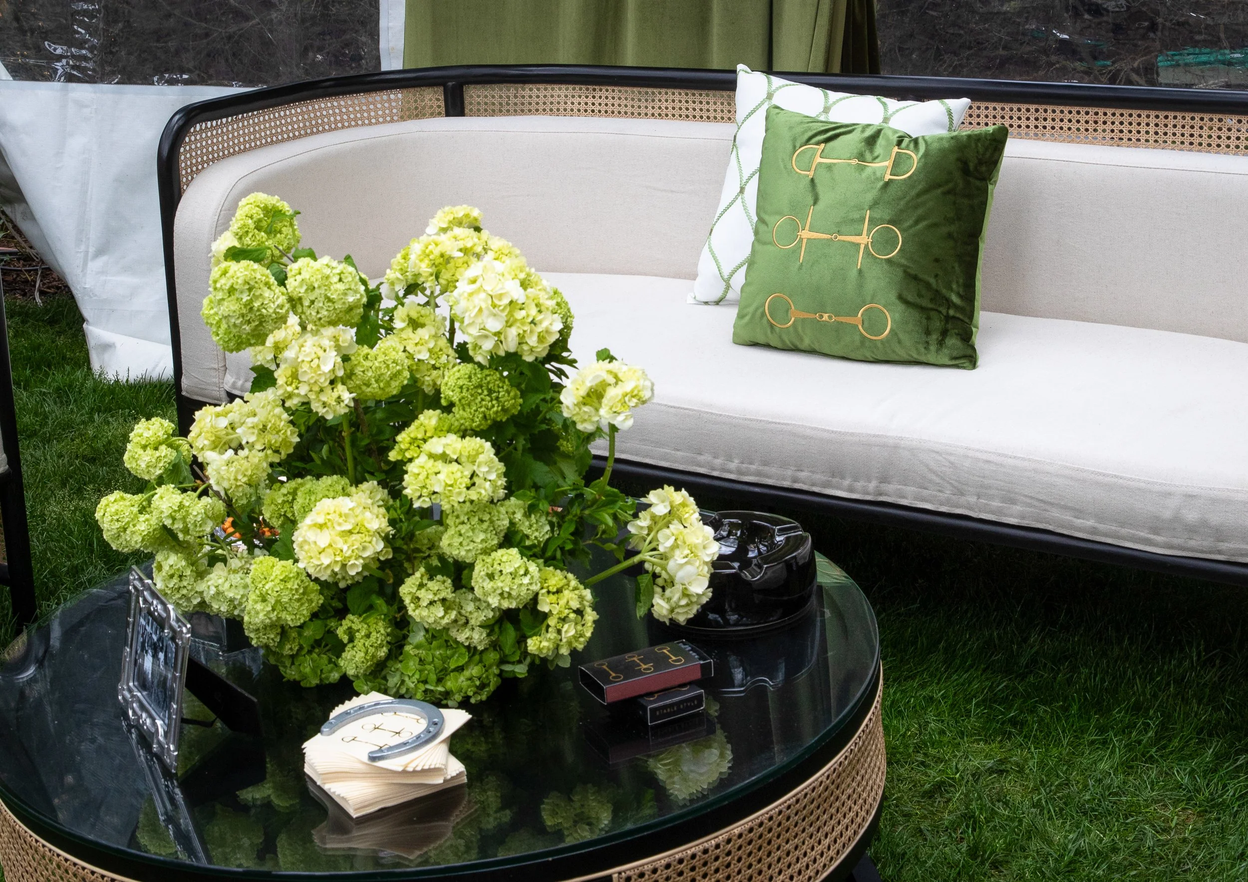 Velvet green linens, tailored lounge furnishings, and hydrangea arrangements created an elevated social club atmosphere inspired by Churchill Downs.