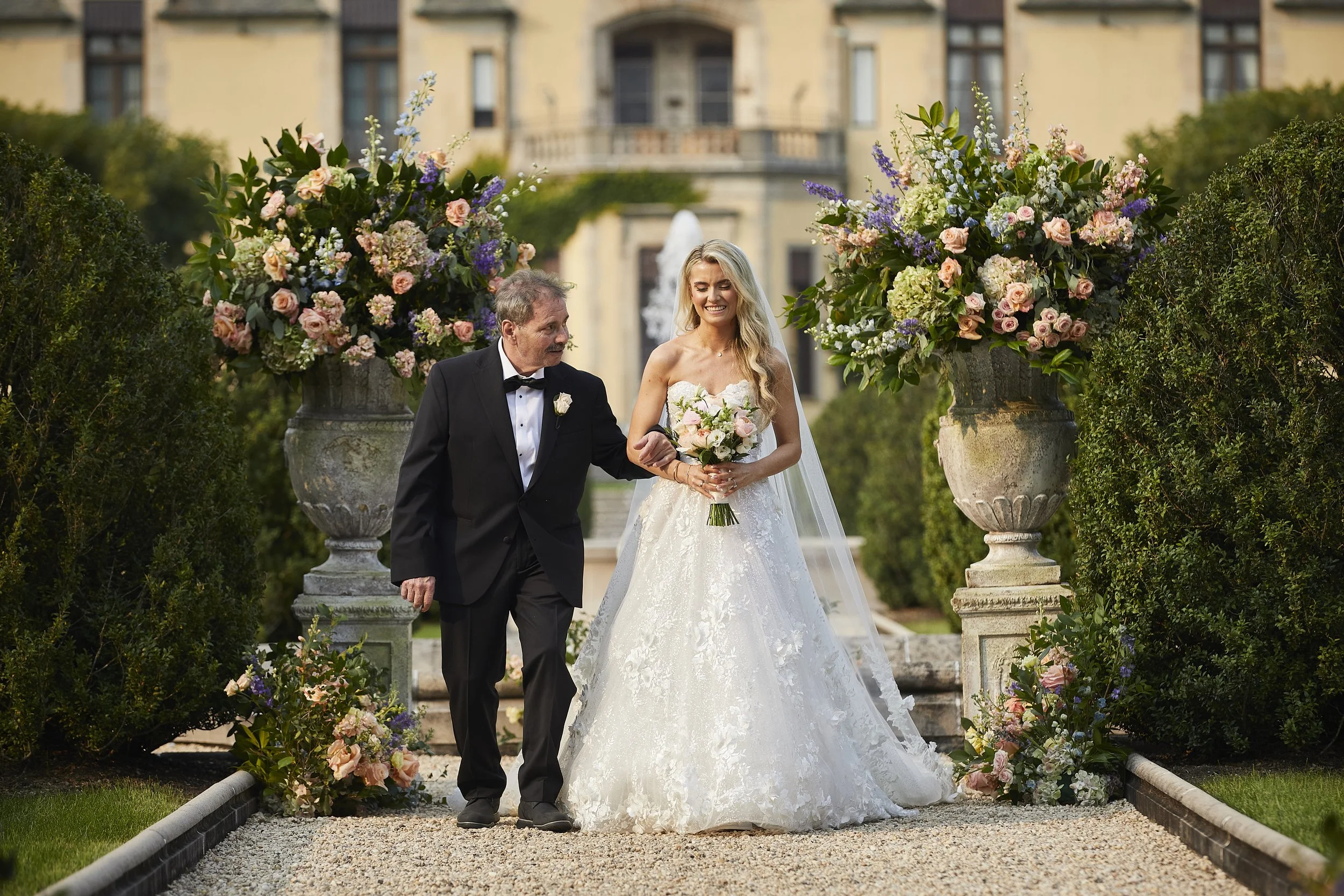 Bride walking down the garden aisle with her father at Oheka Castle ceremony