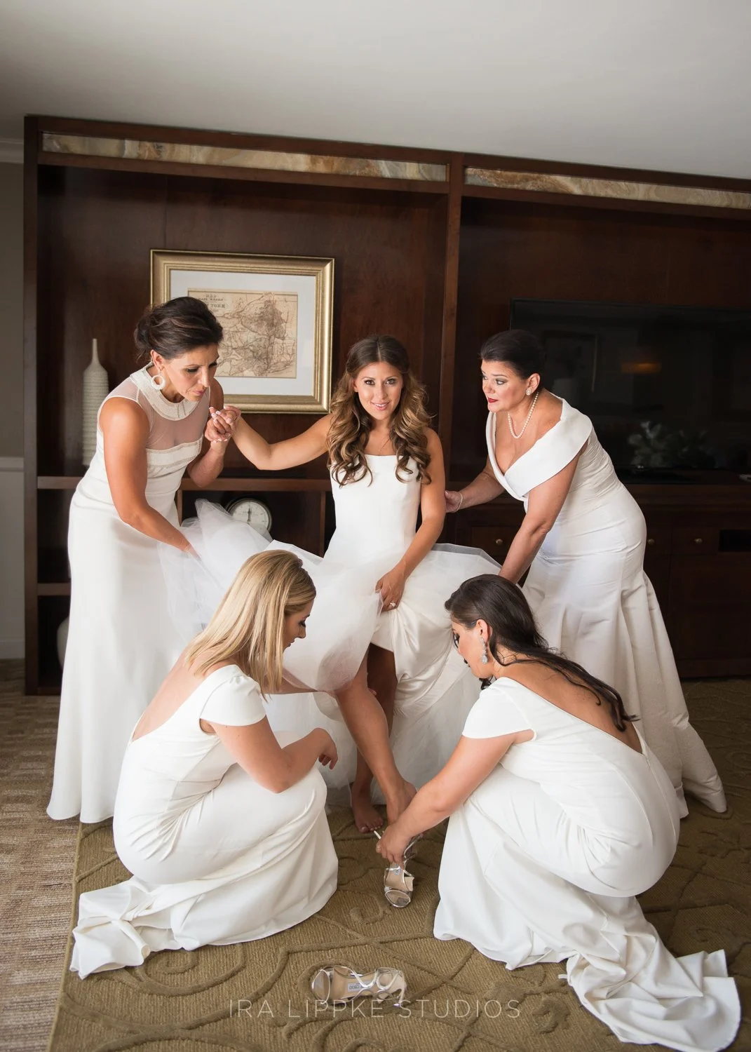 In a beautiful nod to Italian wedding tradition, the bride was surrounded by her mother, bridesmaids, and close family members—all dressed in white—as they helped her into her gown. The custom symbolizes unity, family, and the collective support of t