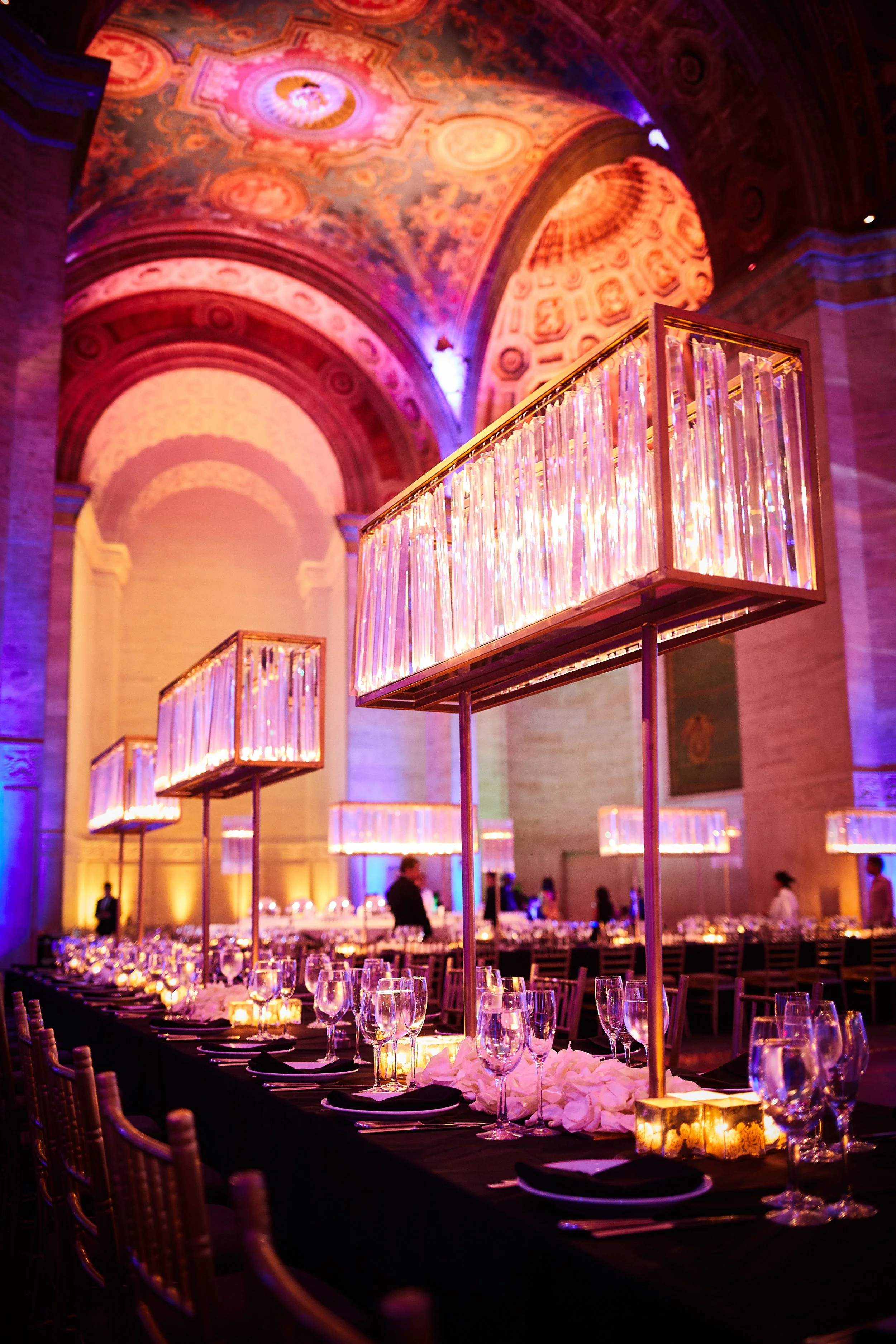 Bar Mitzvah table design with illuminated centerpieces at Cipriani Wall Street in New York City — glowing crystal installations and candlelight layered across long tables, creating a refined and atmospheric dining experience.