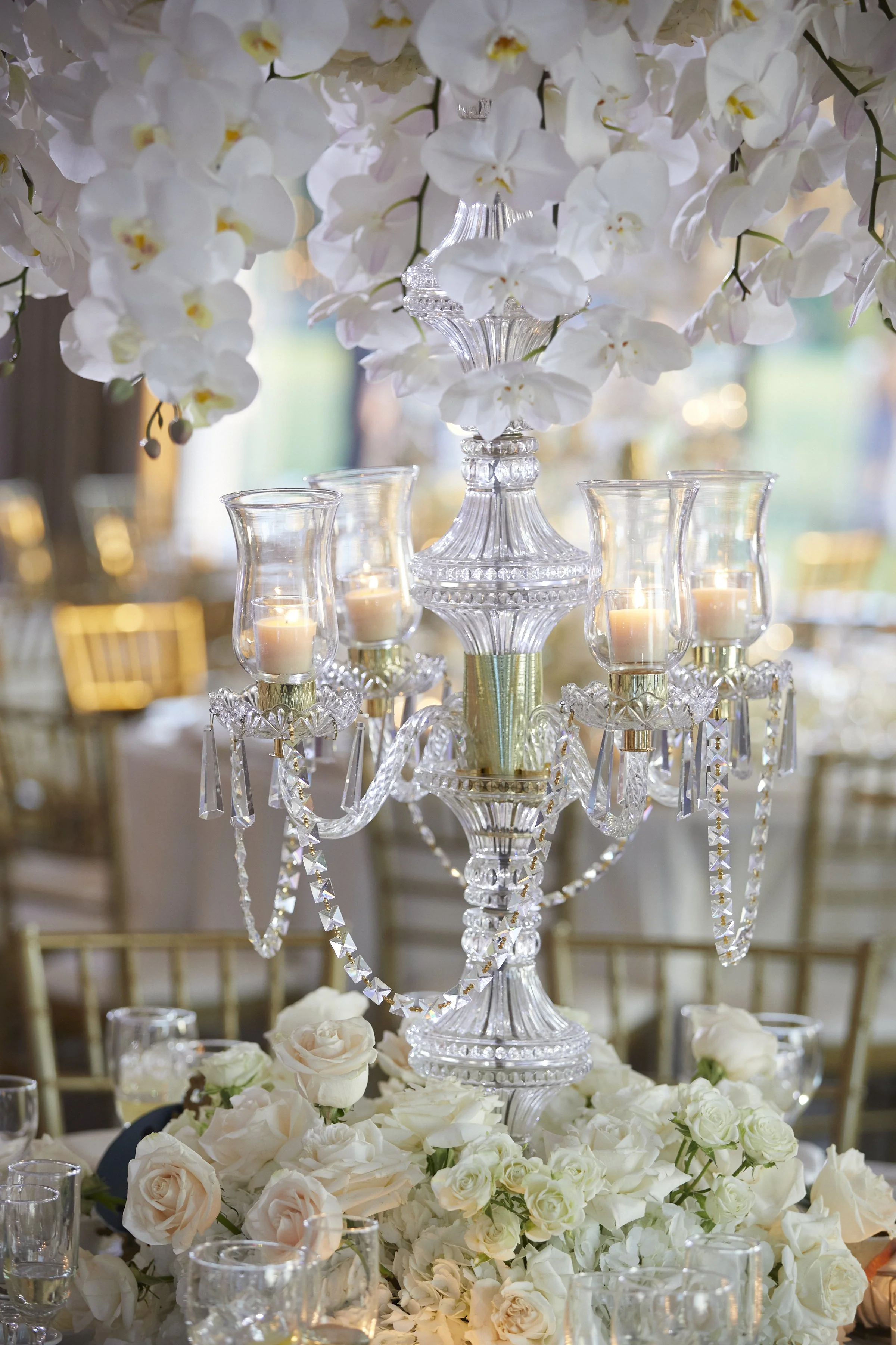 Cut crystal candelabra centerpiece with cascading white phalaenopsis orchids